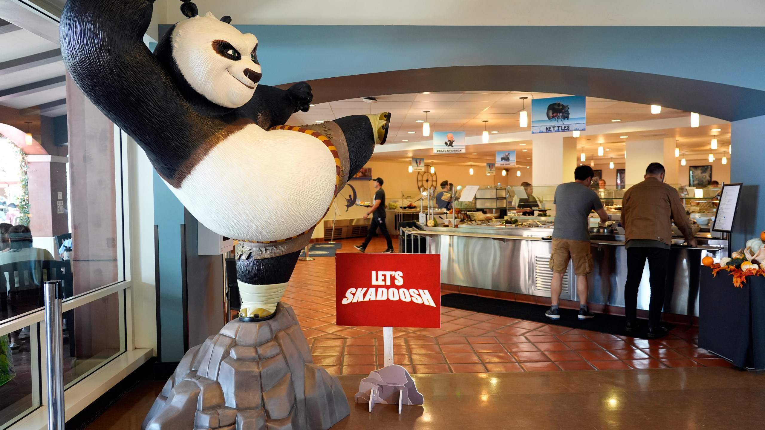 A statue of the DreamWorks Animation character Po, from the "Kung Fu Panda" films, stands near employees inside the DreamWorks commissary, Wednesday, Sept. 25, 2024, in Glendale, Calif. (AP Photo/Chris Pizzello)