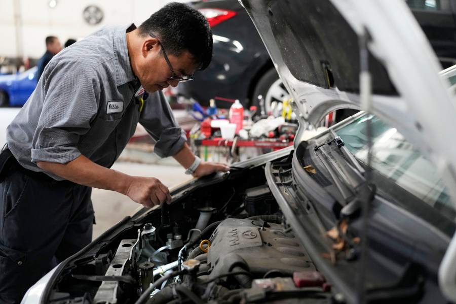 Auto mechanic Willie Chung works on a vehicle at the Express Auto Service Inc., in Chicago, Thursday, Sept. 19, 2024. (AP Photo/Nam Y. Huh)