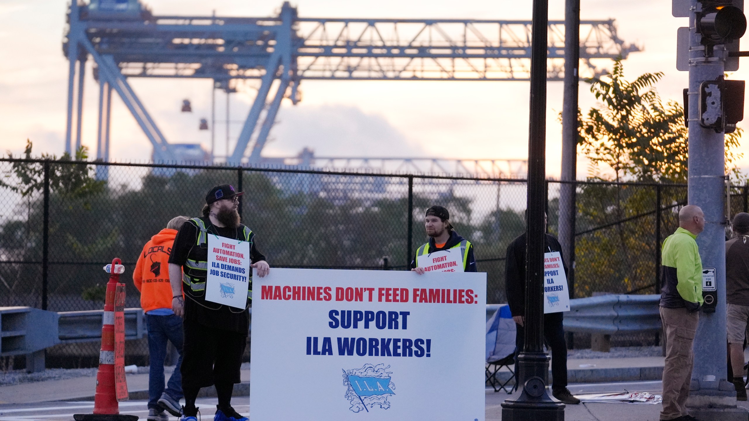 Dockworkers strike in front of an entrance to a container terminal near Boston Harbor, Tuesday, Oct. 1, 2024, in Boston. (AP Photo/Steven Senne)