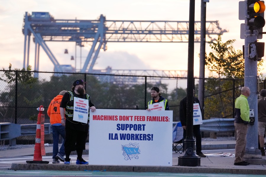 Dockworkers strike in front of an entrance to a container terminal near Boston Harbor, Tuesday, Oct. 1, 2024, in Boston. (AP Photo/Steven Senne)