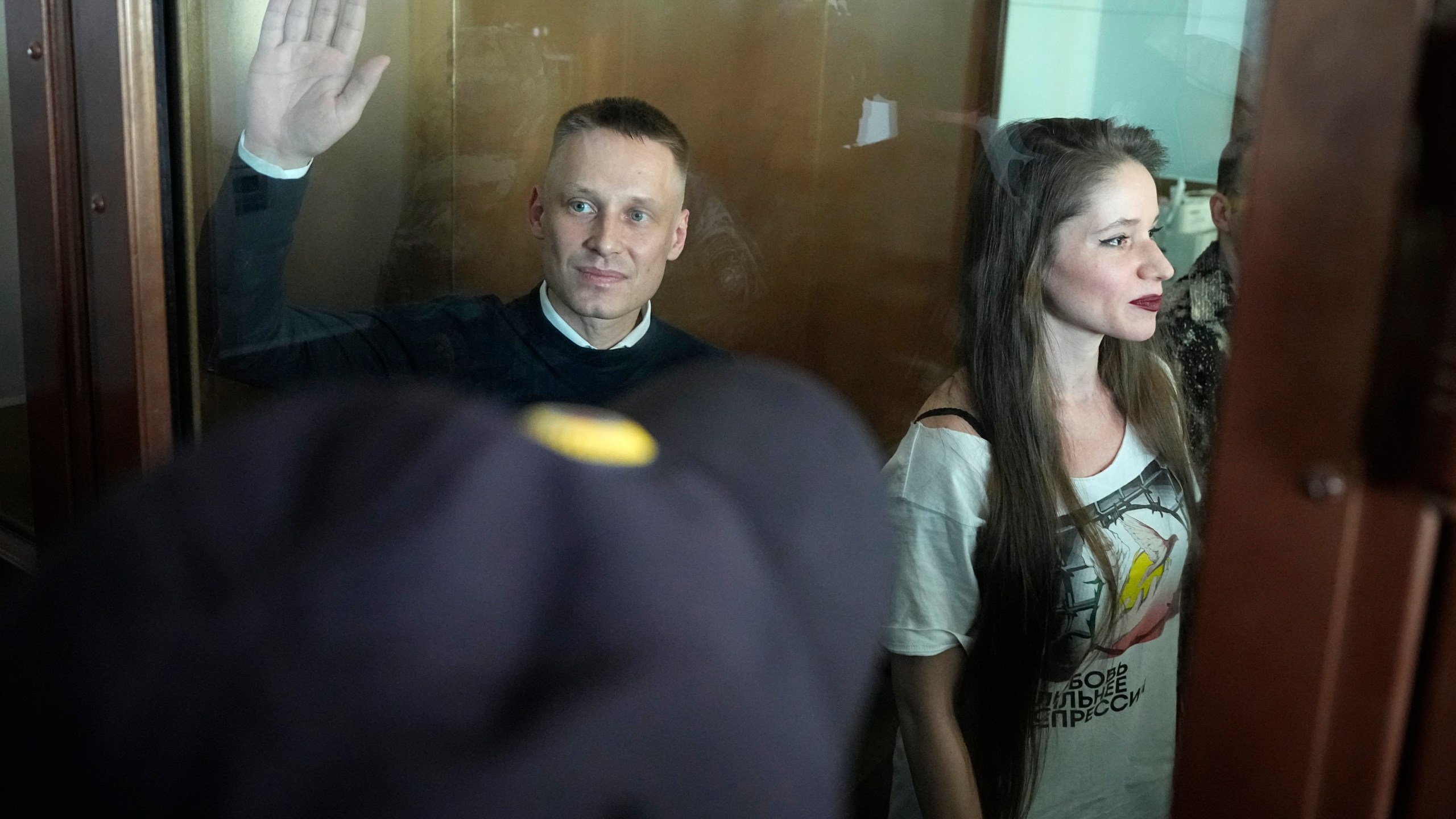 Russian journalists Konstantin Gabov, left, and Antonina Favorskaya, accused of working for a group founded by the late Russian opposition politician Alexei Navalny, stand in a defendant's cage of the Nagatinsky District Court in Moscow, Russia, on Wednesday, Oct. 2, 2024. (AP Photo)