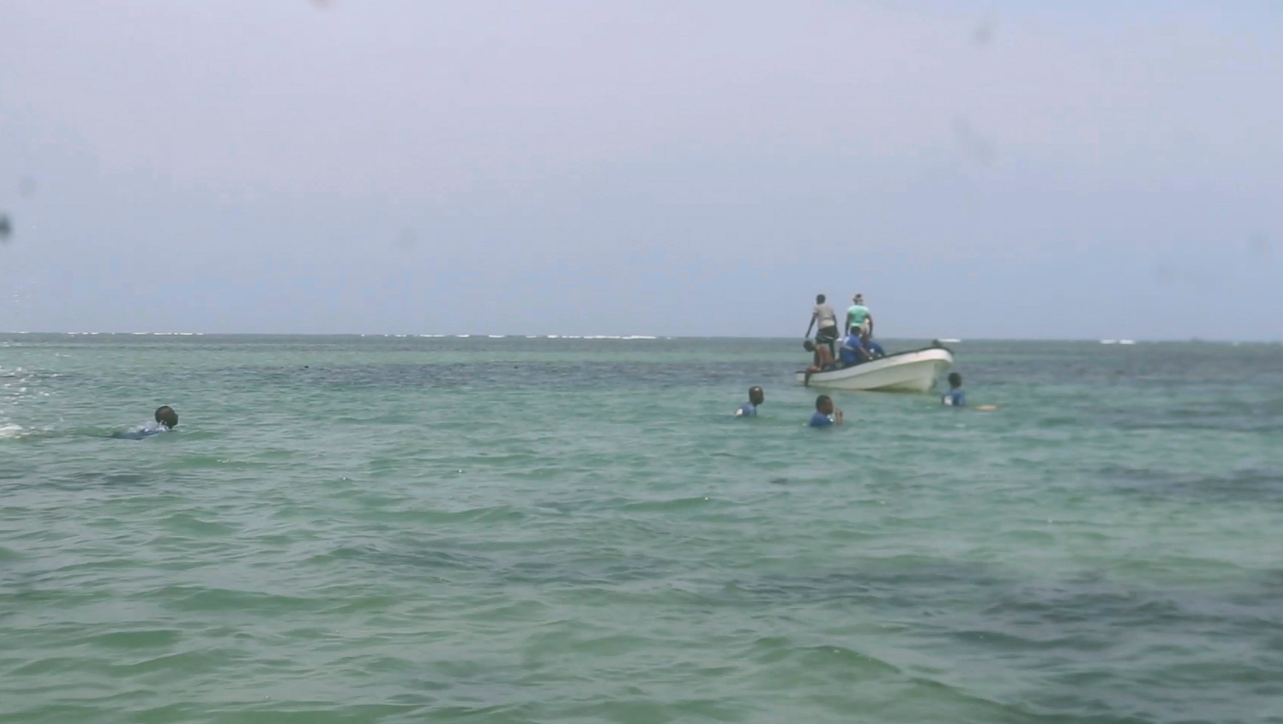 In this image made from video, Djiboutian coast guard workers search for bodies of migrants who were washed away on the shore of the Red Sea, off the coast in Djibouti Wednesday, Oct. 2, 2024. ( Djiboutian Coast Guard via AP)