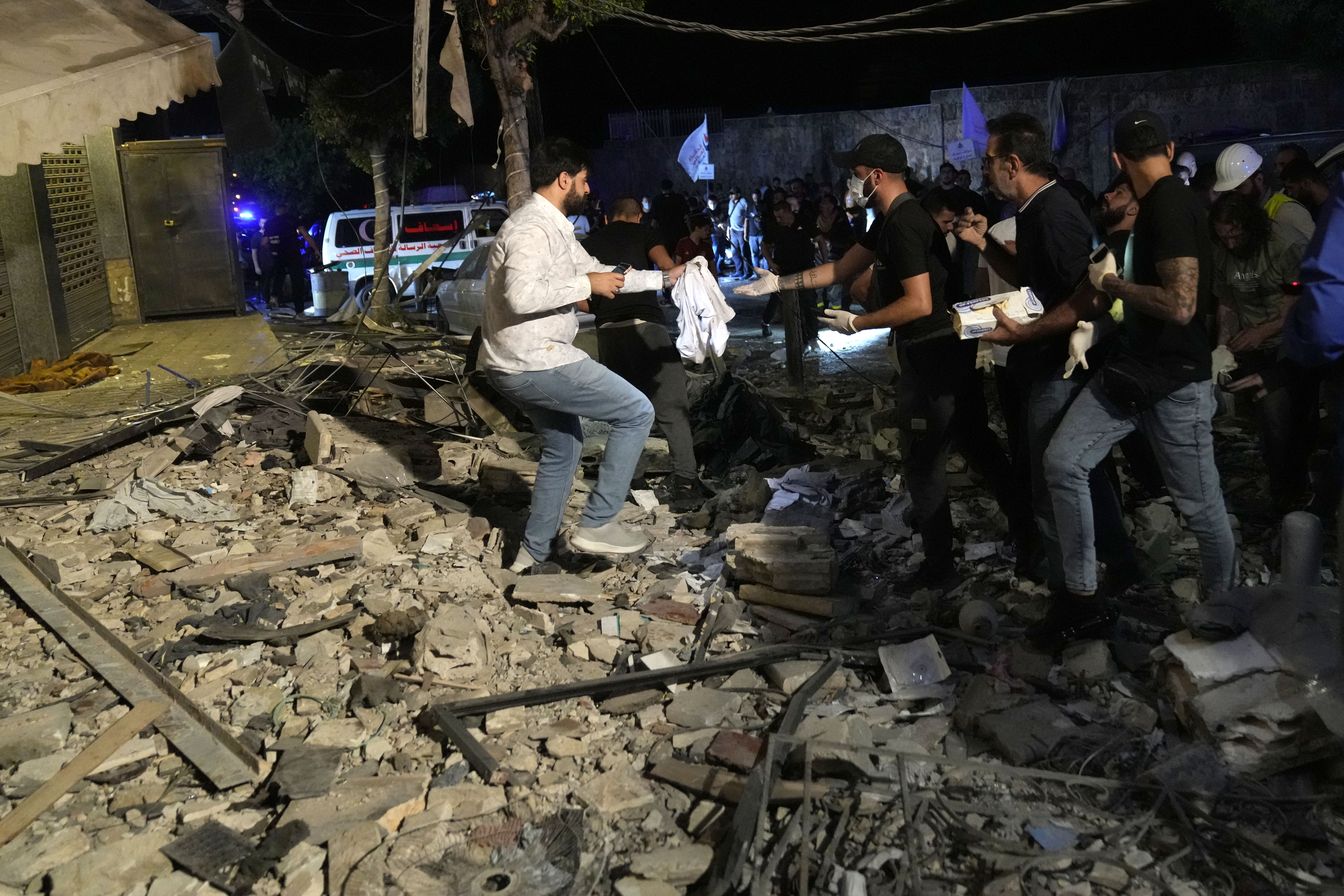 People collecting remains of victims after an airstrike that hit an apartment in Beirut, Lebanon, Thursday, Oct. 3, 2024. (AP Photo/Hussein Malla)