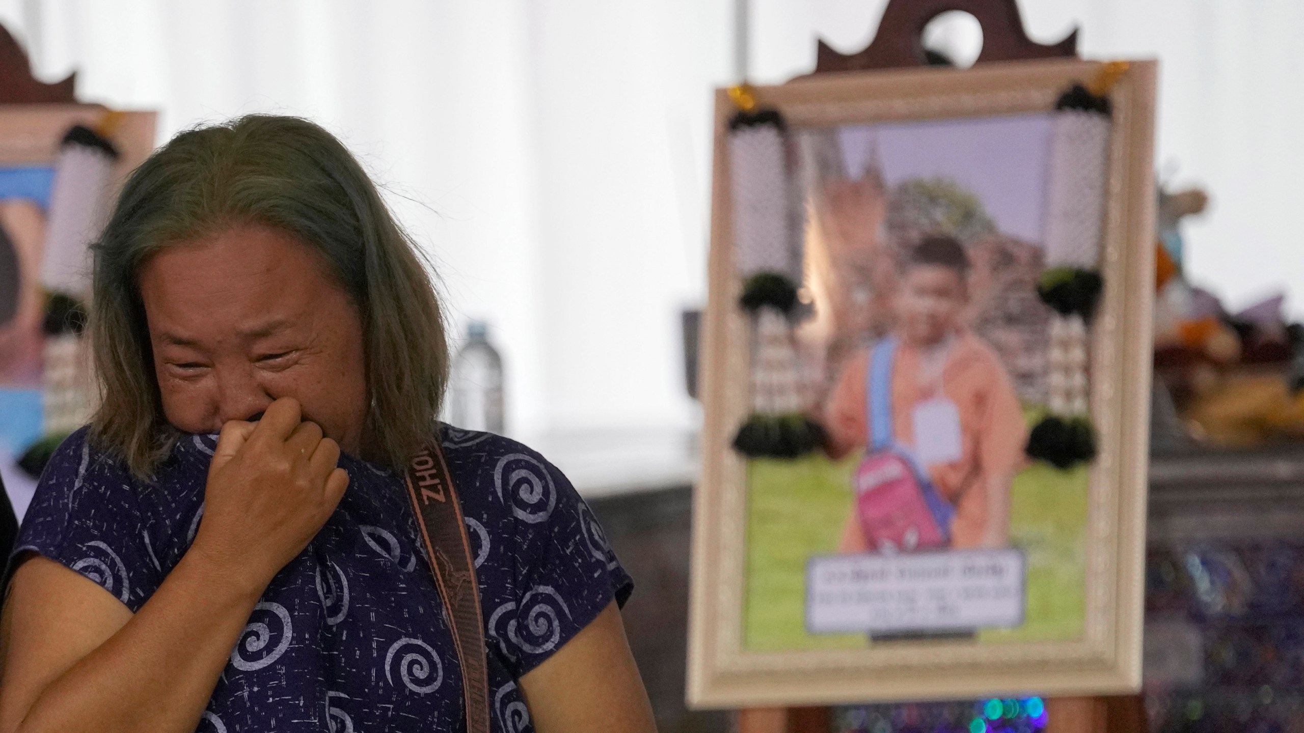 A relative wails near the coffin of a victim of school bus fire at Wat Khao Phraya Sangkharam School, Lan Sak, Uthai Thani province, Thailand, Thursday, Oct. 3, 2024. (AP Photo/Sakchai Lalit)