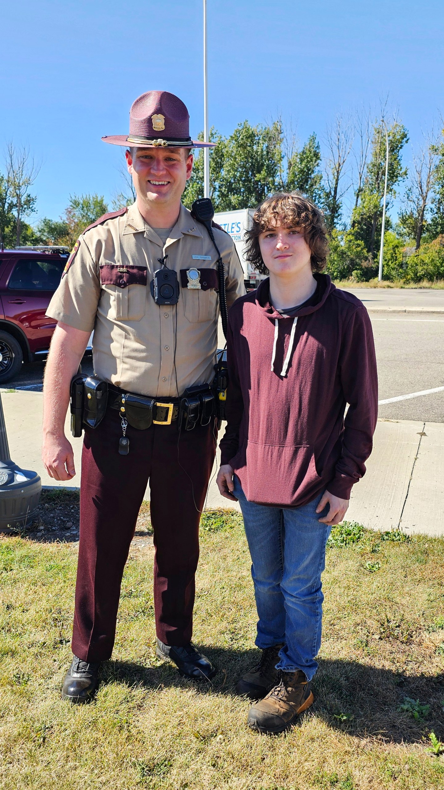 This photo provided by Catherine Dutcher shows Sam Dutcher with Minnesota State Patrol Trooper Zach Gruver at the Travel Center in Moorhead, Minn., Wednesday, Sept. 25, 2024. (Catherine Dutcher via AP)