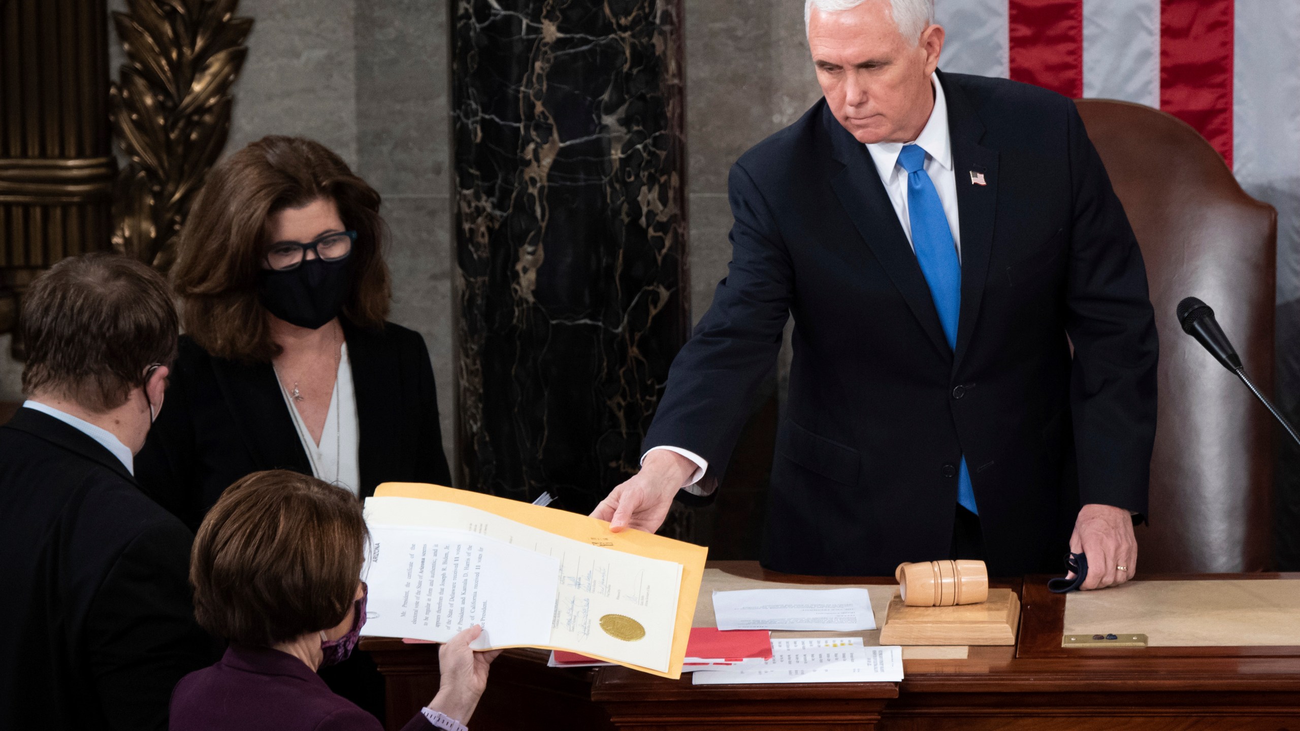 FILE - Vice President Mike Pence hands the electoral certificate from the state of Arizona to Sen. Amy Klobuchar, D-Minn., as he presides over a joint session of Congress as it convenes to count the Electoral College votes cast in November's election, at the Capitol in Washington, Jan. 6, 2021. (Saul Loeb/Pool via AP, File)