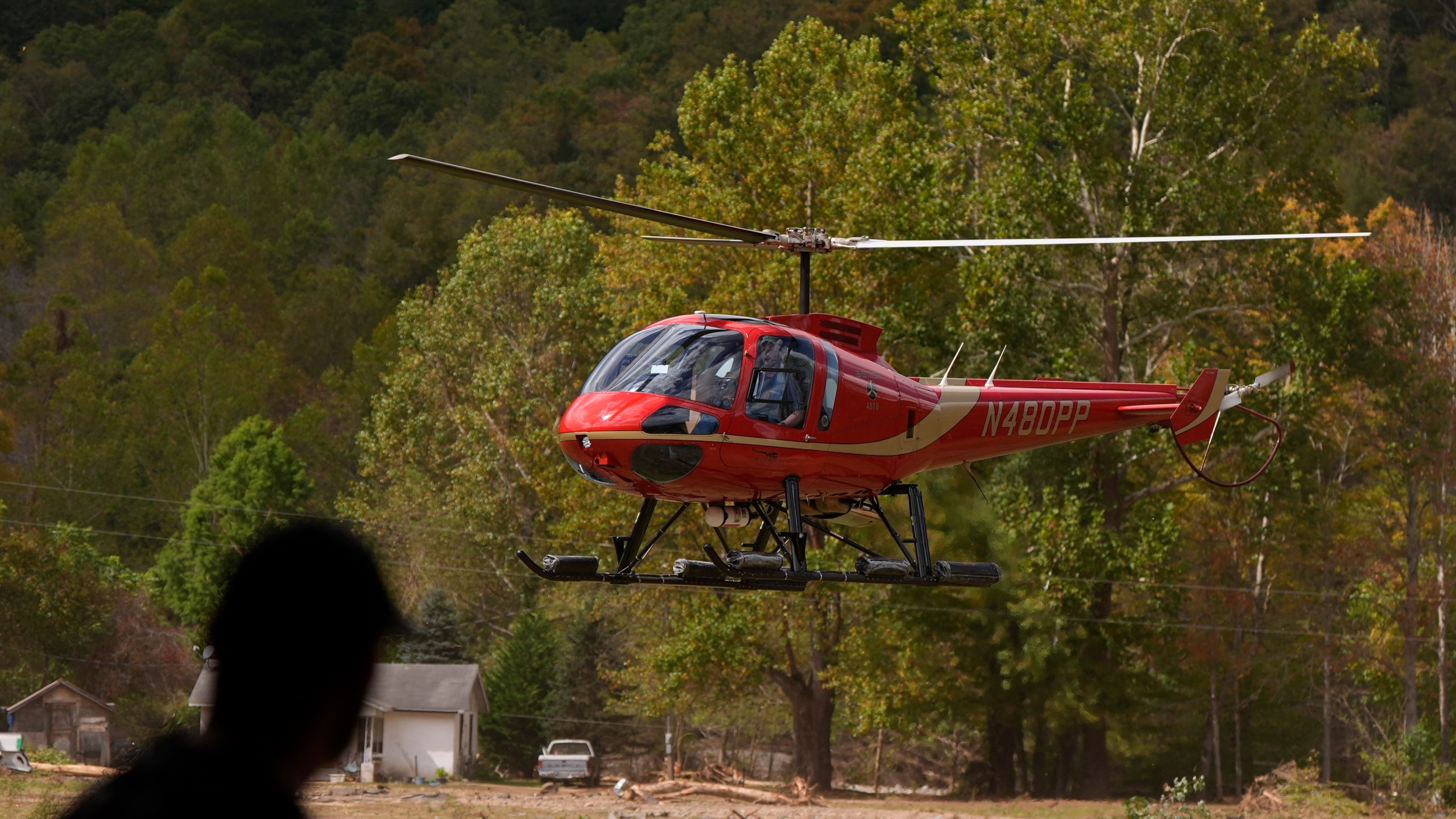 A firefighter watches as a helicopter lands at a volunteer fire station in the aftermath of Hurricane Helene, Thursday, Oct. 3, 2024, in Pensacola, N.C. (AP Photo/Mike Stewart)