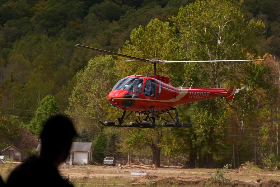 A firefighter watches as a helicopter lands at a volunteer fire station in the aftermath of Hurricane Helene, Thursday, Oct. 3, 2024, in Pensacola, N.C. (AP Photo/Mike Stewart)