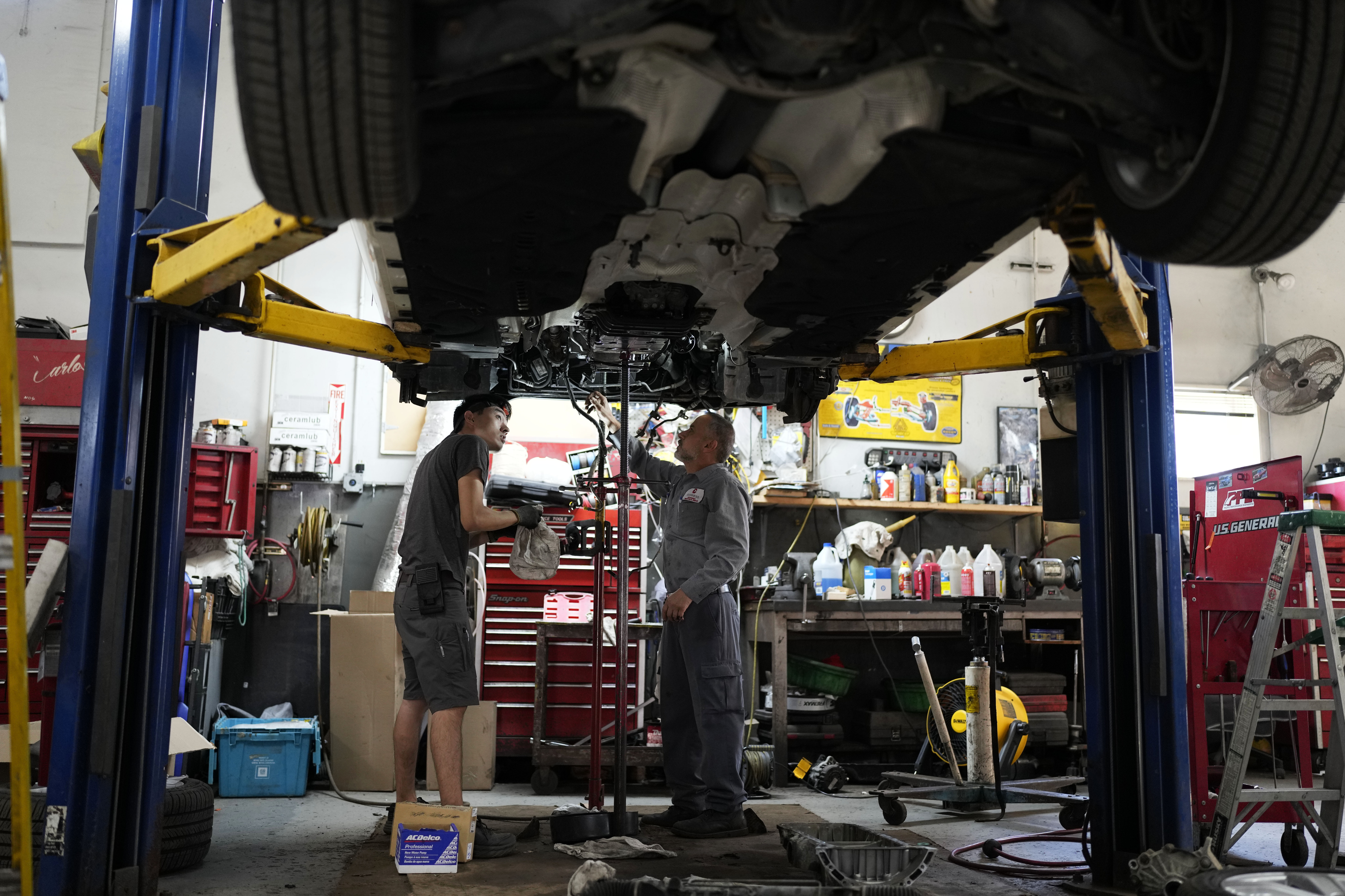 FILE - Auto mechanics work on a vehicle at the Express Auto Service Inc., in Chicago, Sept. 19, 2024. (AP Photo/Nam Y. Huh, File)