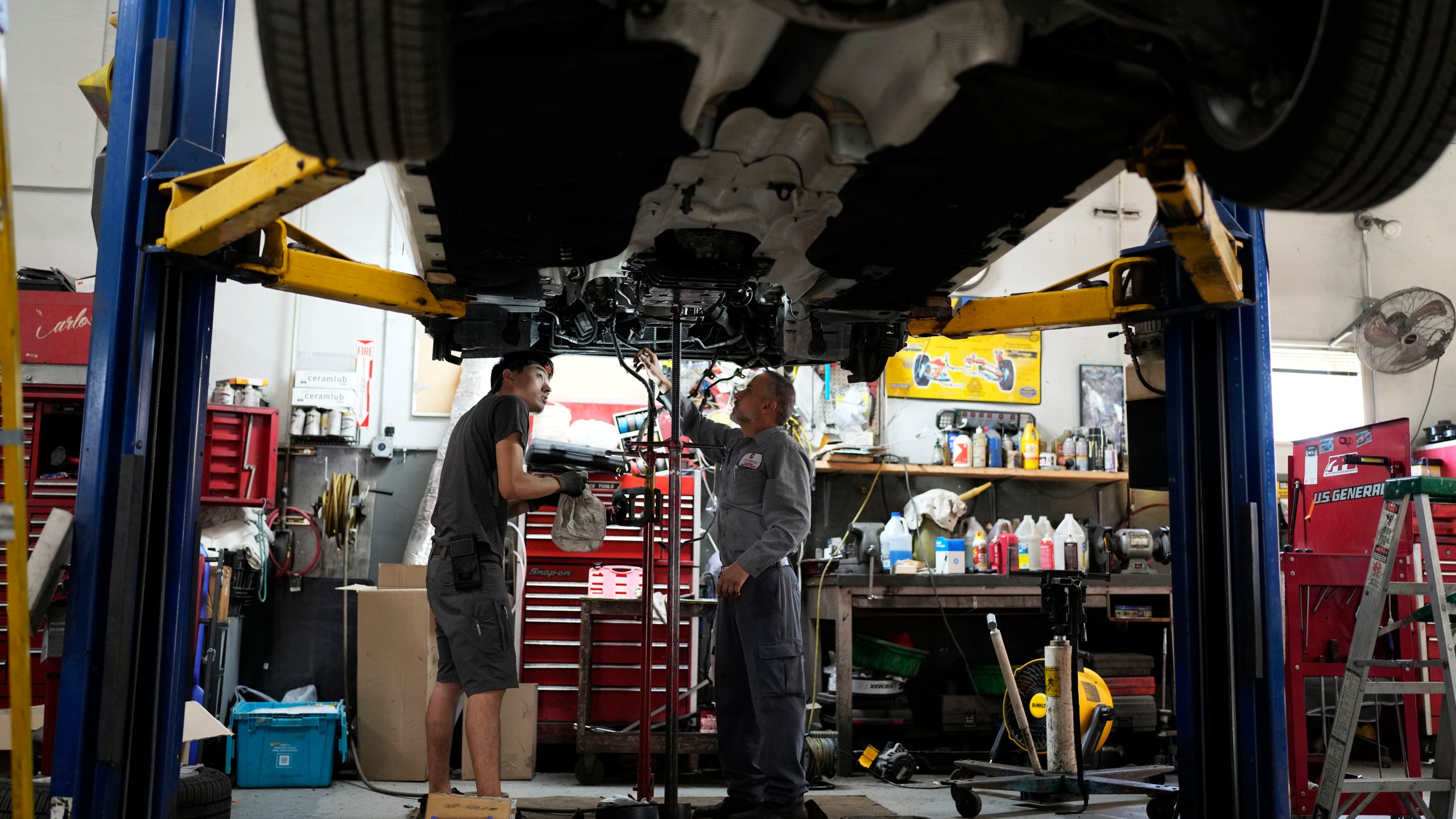 FILE - Auto mechanics work on a vehicle at the Express Auto Service Inc., in Chicago, Sept. 19, 2024. (AP Photo/Nam Y. Huh, File)