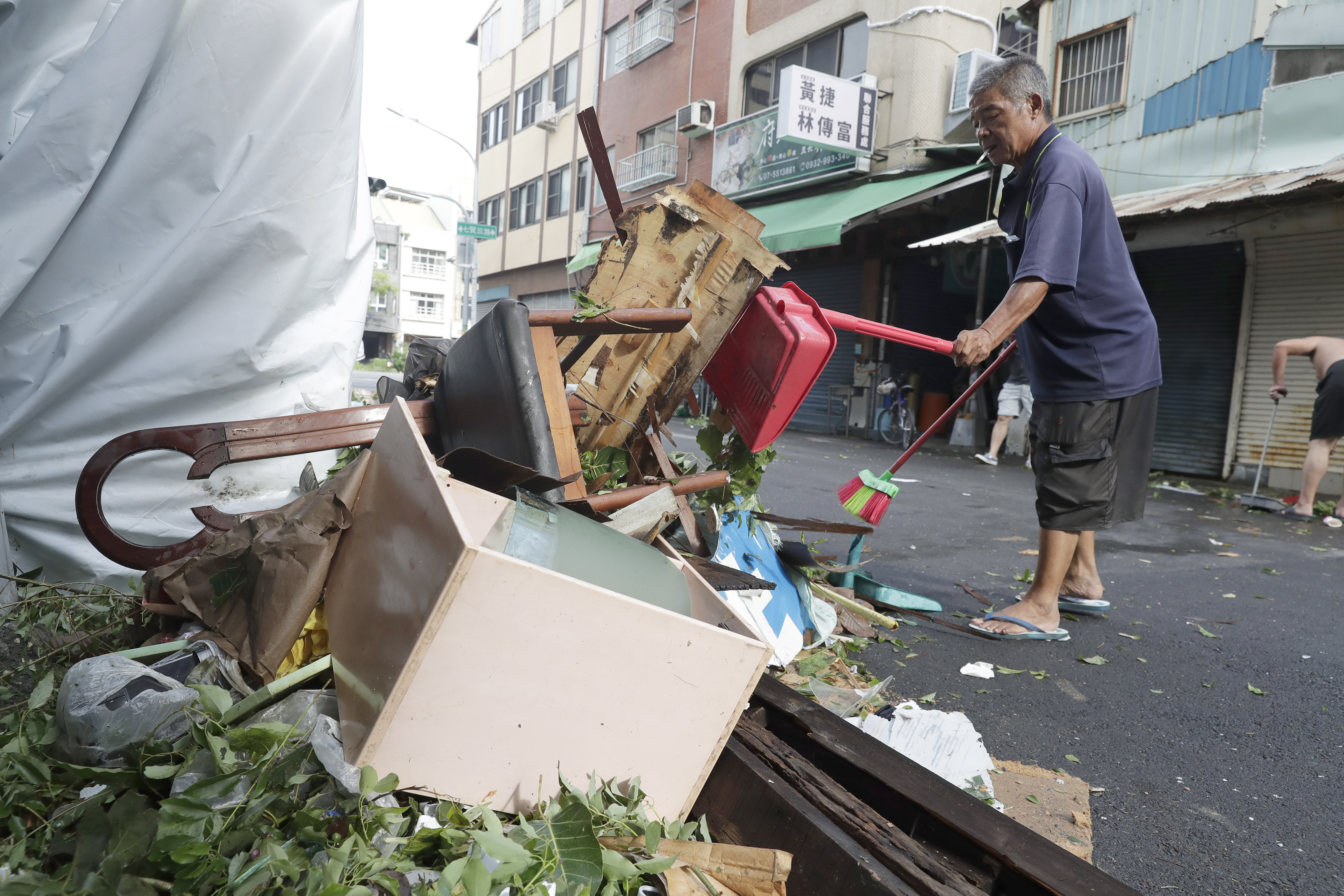 A man clears debris in the aftermath of Typhoon Krathon in Kaohsiung, southern Taiwan, Friday, Oct. 4, 2024. (AP Photo/Chiang Ying-ying)