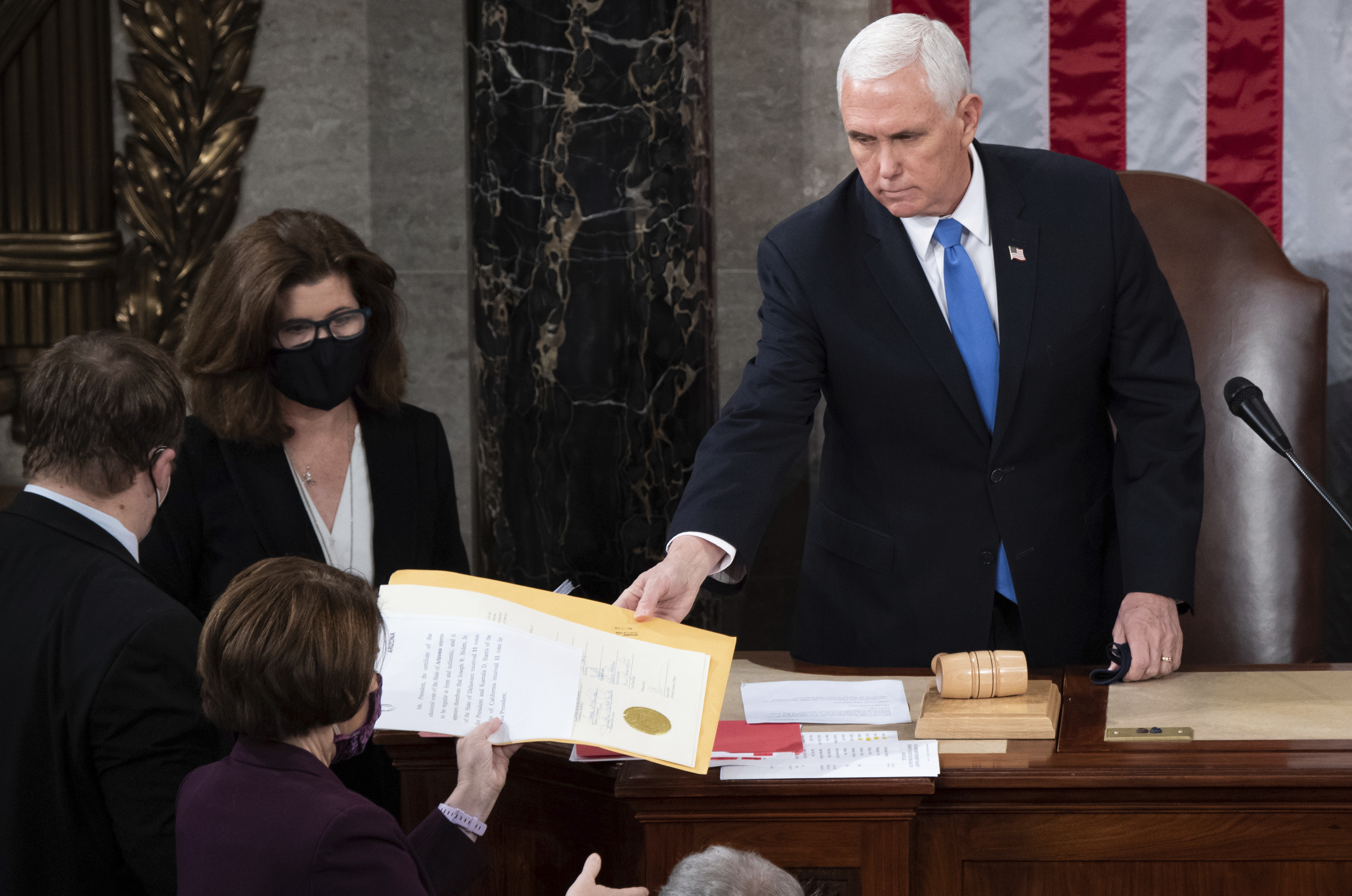 FILE - Vice President Mike Pence hands the electoral certificate from the state of Arizona to Sen. Amy Klobuchar, D-Minn., as he presides over a joint session of Congress as it convenes to count the Electoral College votes cast in November's election, at the Capitol in Washington, Jan. 6, 2021. (Saul Loeb/Pool via AP, File)