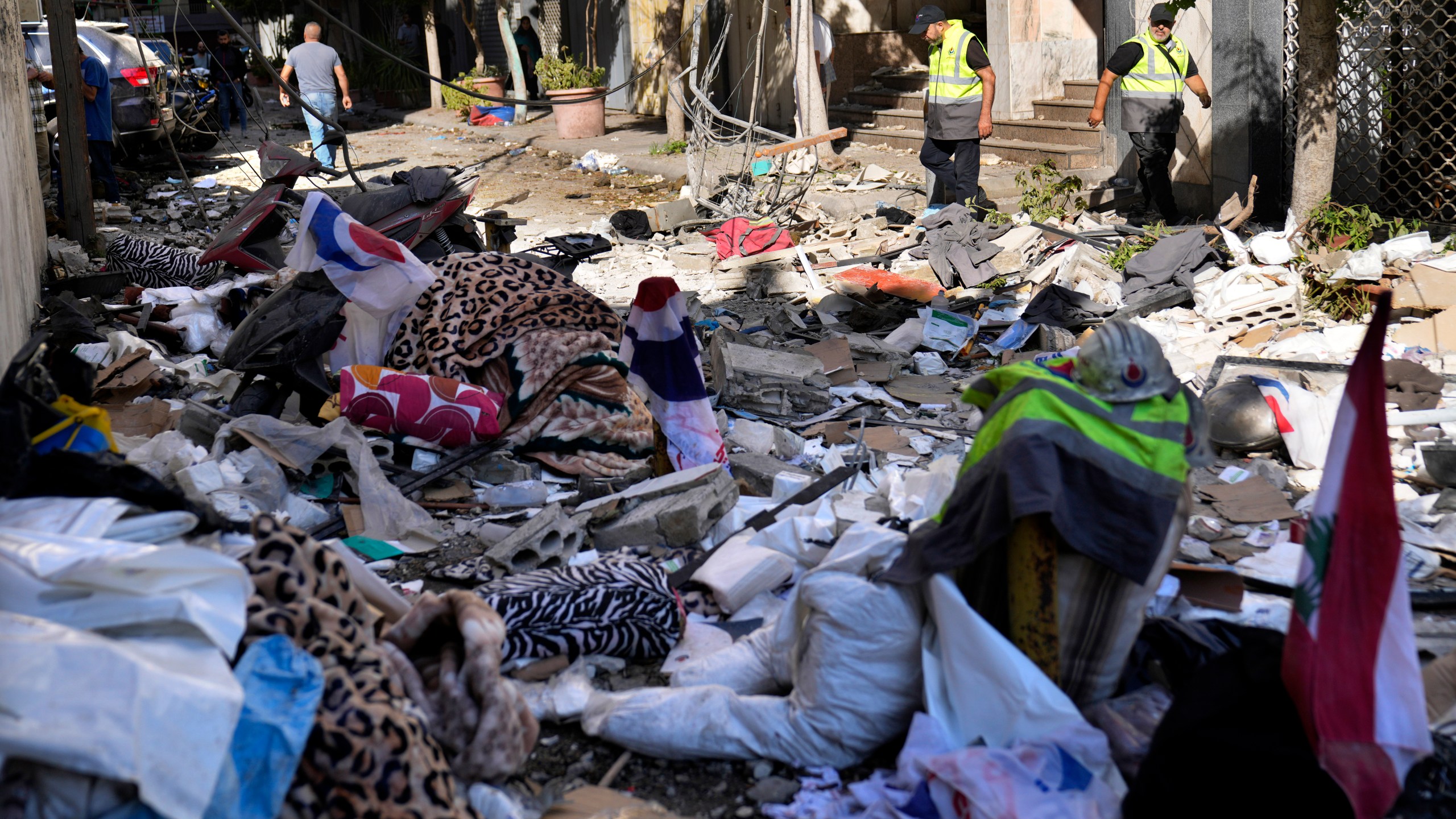 Hezbollah paramedics walk between debris after an airstrike hit an apartment in a multistory building, in central Beirut, Lebanon, Thursday, Oct. 3, 2024. (AP Photo/Hussein Malla)