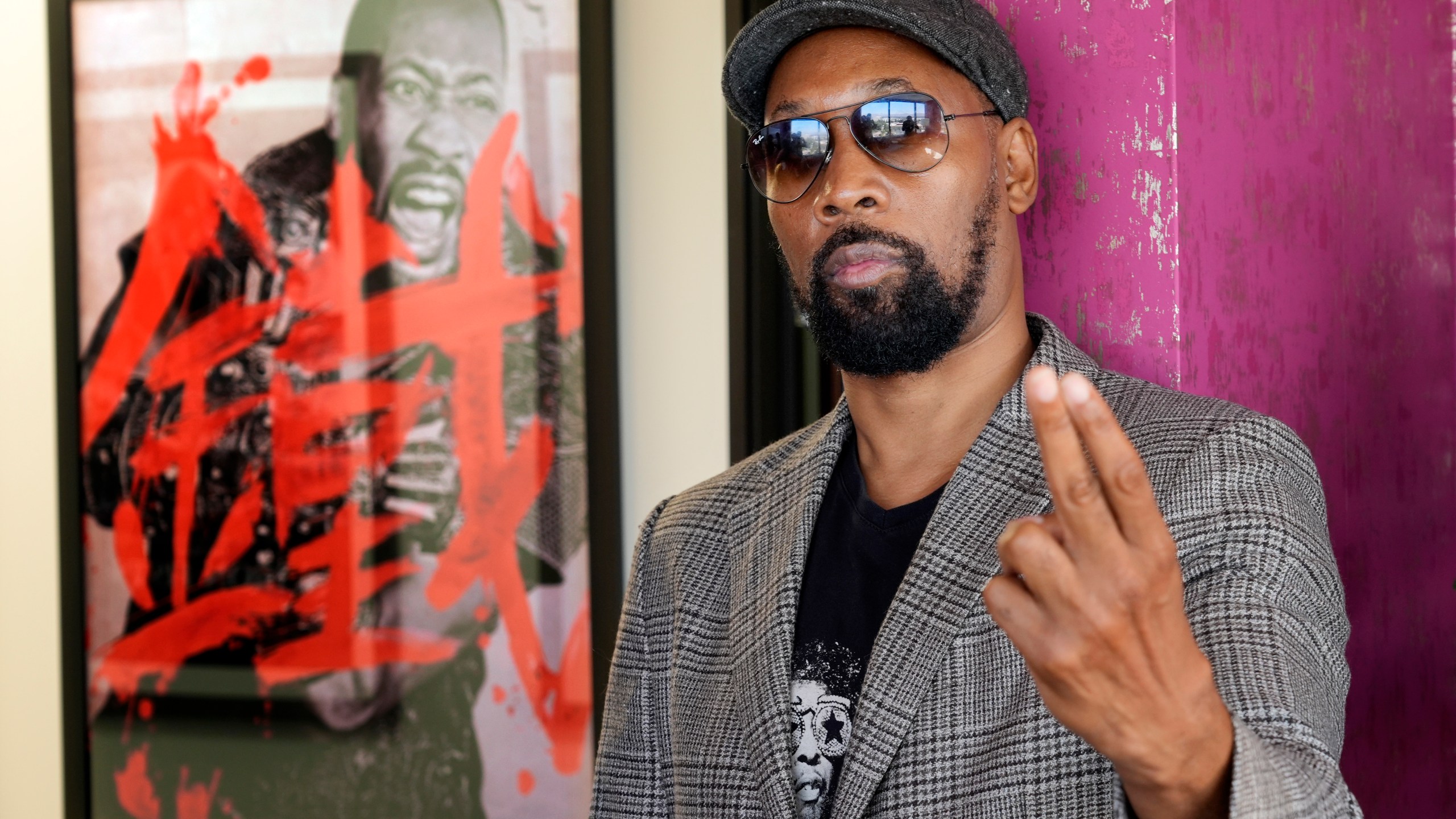 Musician, actor and filmmaker RZA poses for a portrait near a poster for his 2012 film "The Man with the Iron Fists" at his office, Wednesday, Aug. 28, 2024, in Los Angeles. (AP Photo/Chris Pizzello)