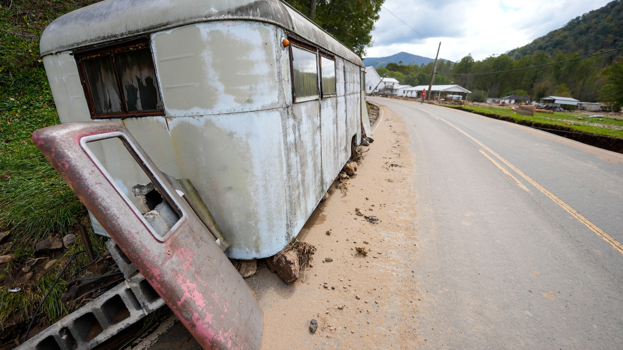 A trailer moved by floodwater sits on the side of a road in the aftermath of Hurricane Helene, Thursday, Oct. 3, 2024, in Pensacola, N.C. (AP Photo/Mike Stewart)