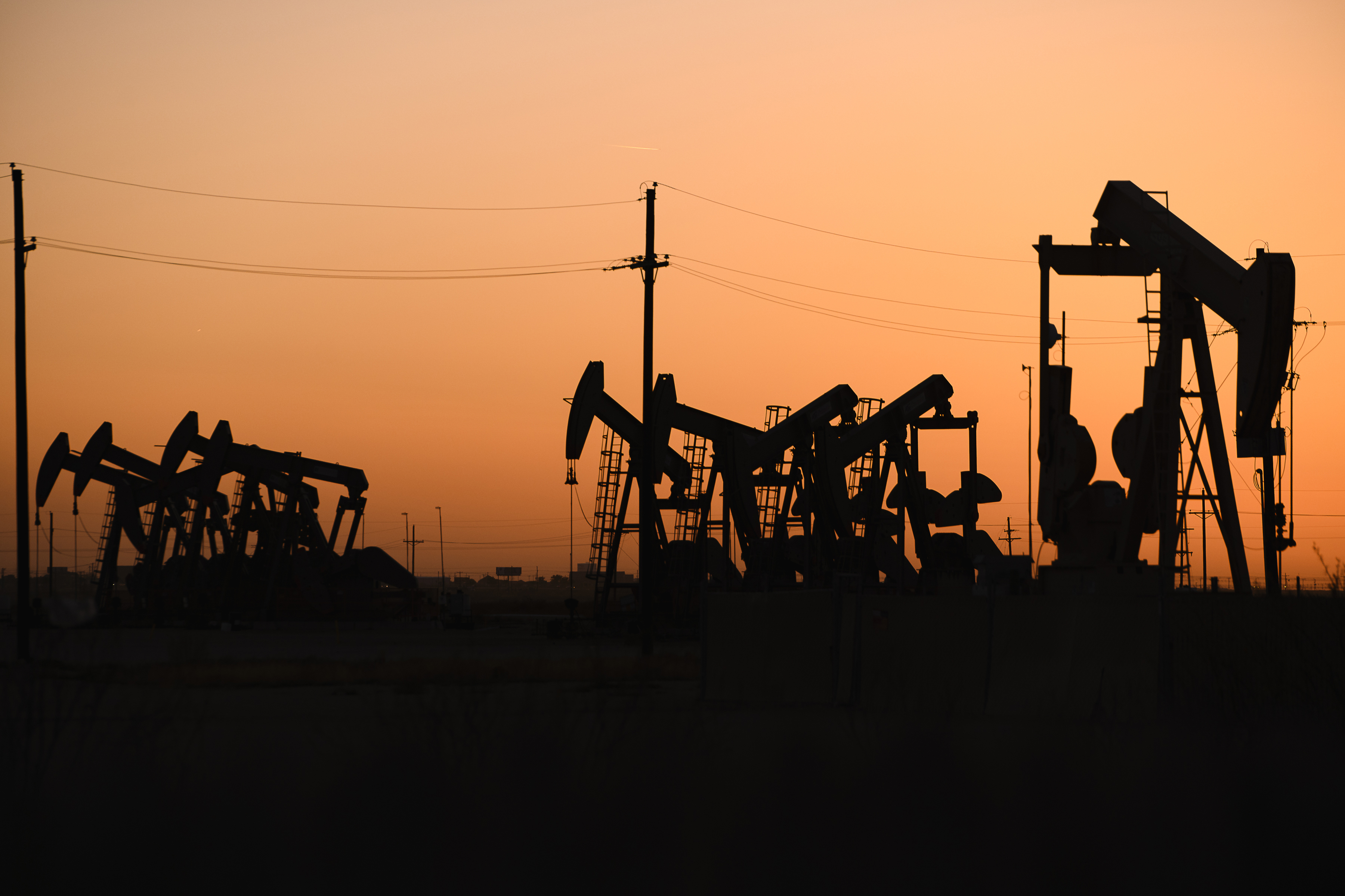 FILE - An array of pumpjacks operate near the site of a new oil and gas well being drilled April 8, 2022 in Midland, Texas. (Eli Hartman/Odessa American via AP, File)