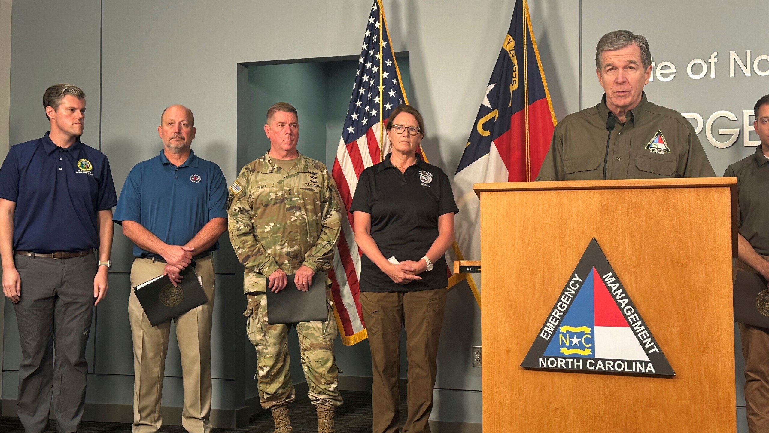 North Carolina Gov. Roy Cooper, right at podium, speaks during a media briefing on the government response to Hurricane Helene in western North Carolina while Federal Emergency Management Agency Administrator Deanne Criswell, center, and others listen at the state Emergency Operations Center in Raleigh, N.C., Tuesday, Oct. 1, 2024. (AP Photo/Gary D. Robertson)