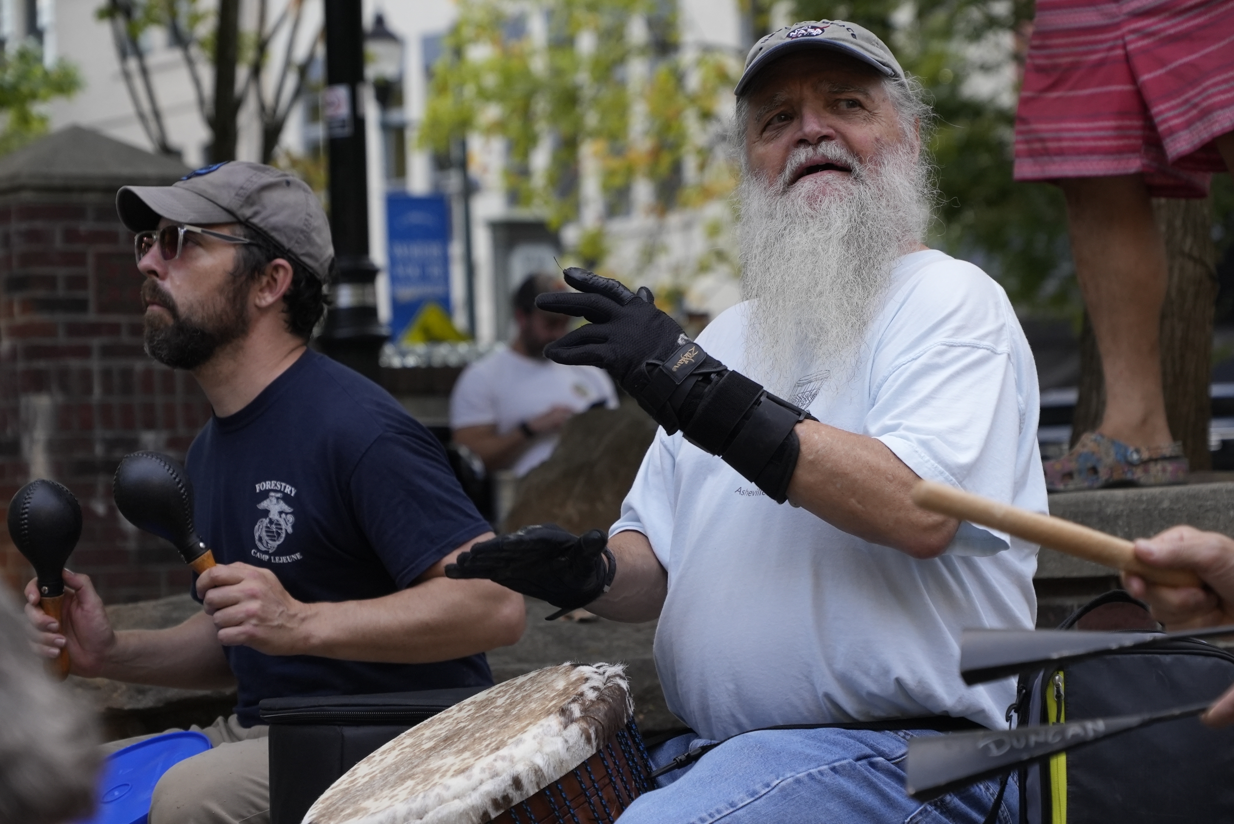 Mel McDonald plays music at a drum circle Friday, Oct. 4, 2024 in Asheville, N.C., a week after Hurricane Helene upended lives across the Southeast. (AP Photo/Brittany Peterson)