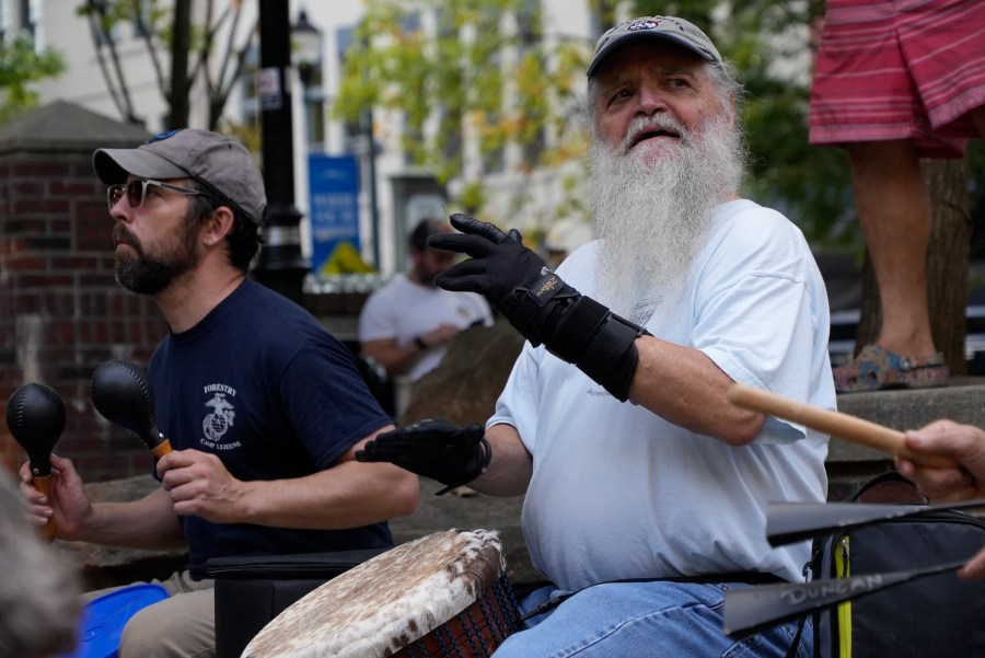 Mel McDonald plays music at a drum circle Friday, Oct. 4, 2024 in Asheville, N.C., a week after Hurricane Helene upended lives across the Southeast. (AP Photo/Brittany Peterson)