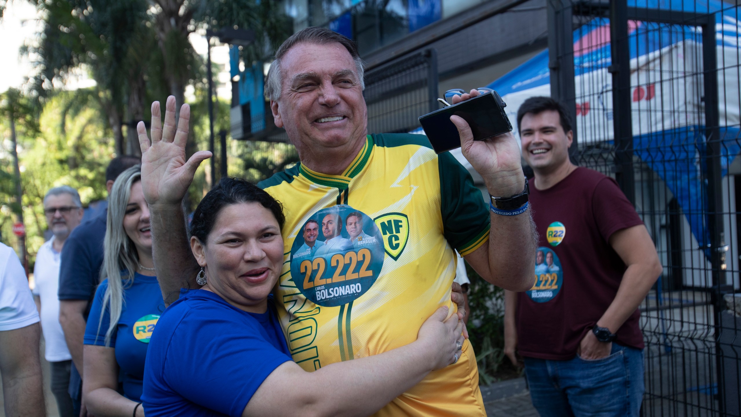 A supporter hugs former Brazilian President Jair Bolsonaro, center, as he supports for Rio de Janeiro mayoral candidate Alexandre Ramagem during municipal elections in Rio de Janeiro, Sunday, Oct. 6, 2024. (AP Photo/Bruna Prado)