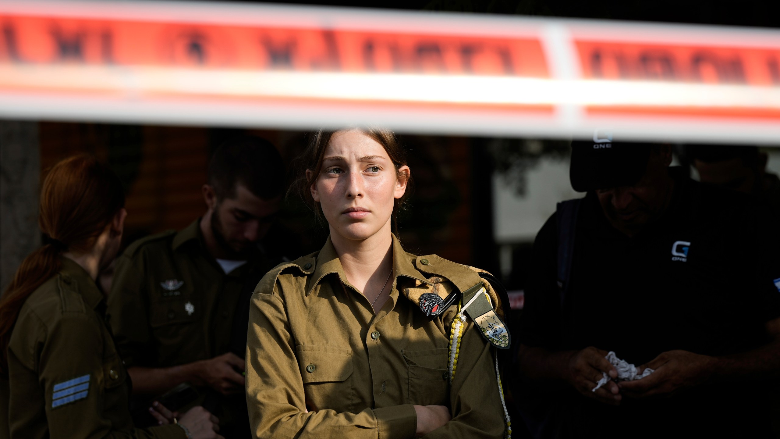 An Israeli soldier looks at the scene of a stabbing and shooting attack where Israel's Magen David Adom rescue service said one person was killed and several others were wounded in Beersheba, Israel, Sunday, Oct. 6, 2024. (AP Photo/Tsafrir Abayov)