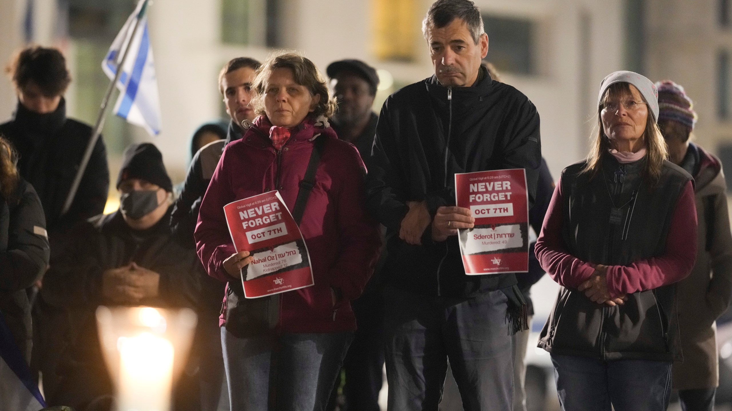 People attend the reading the names of the victims of the Hamas attack on Israel during a commemoration to mark the first anniversary of the attack, at the Brandenburg Gate in Berlin, Germany, Monday, Oct. 7, 2024. (AP Photo/Markus Schreiber)