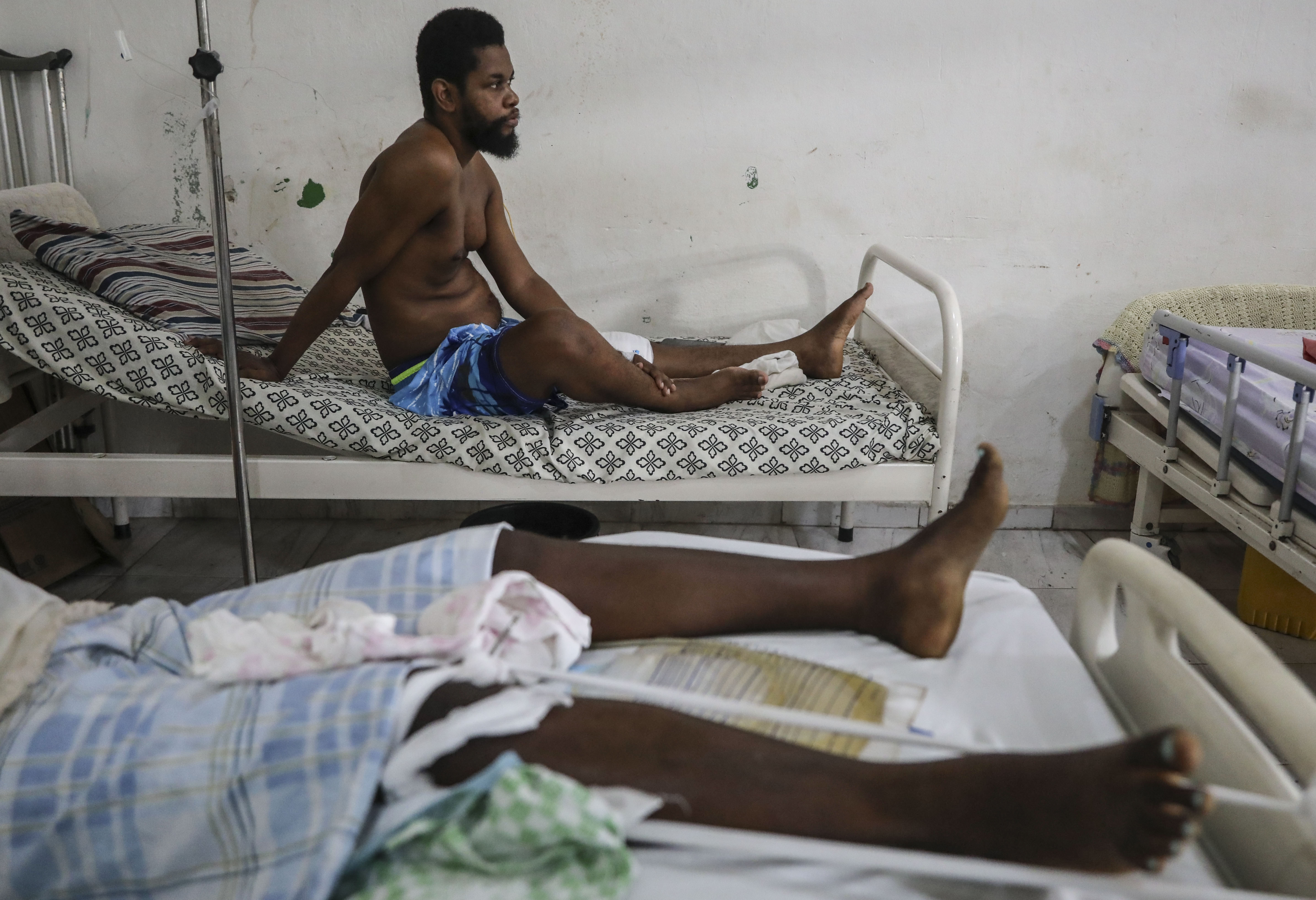 Exiles Junior, wounded by a bullet during armed gang attacks, sits up on a bed at Saint Nicolas hospital in Saint-Marc, Haiti, Sunday, Oct. 6, 2024. (AP Photo/Odelyn Joseph)