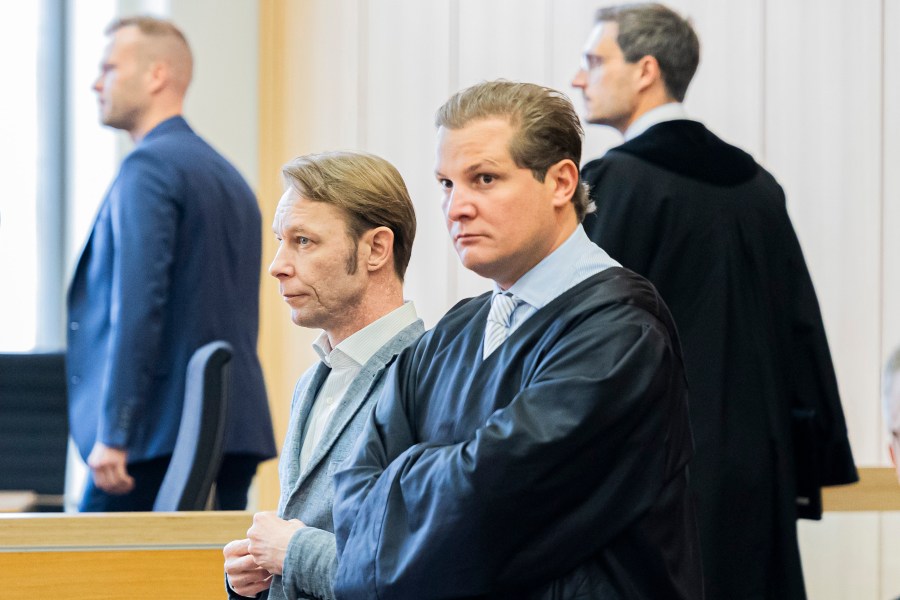 Christian Brueckner, center, stands in the courtroom at Braunschweig District Court before the start of the trial, in Brunswick, Germany, Tuesday Oct. 8, 2024. (Michael Matthey/dpa via AP)