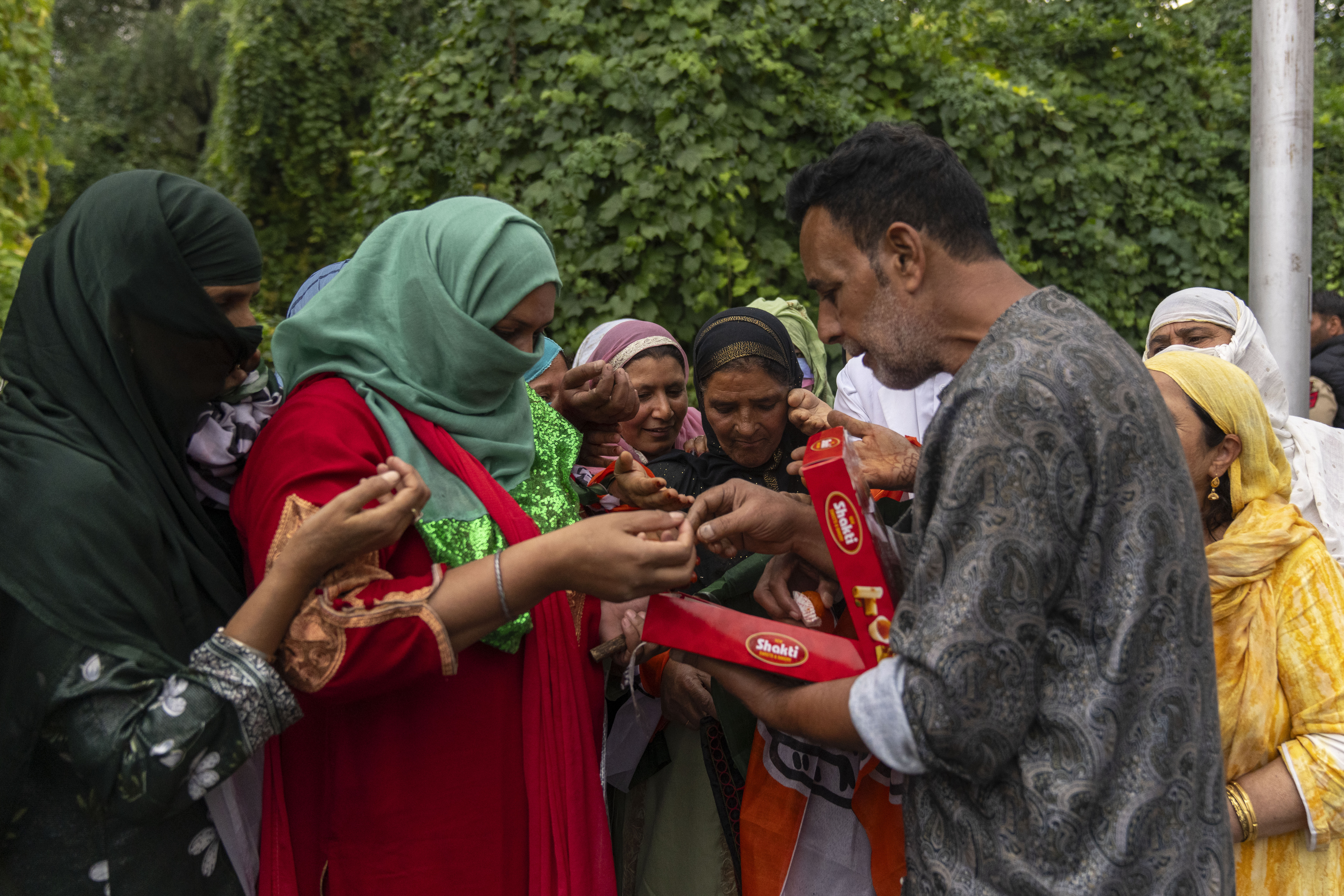 Kashmiri man distributes sweets among supporters of Indian National Congress and National Conference party as they celebrate early leads in the election for a local government in Indian controlled Kashmir, Srinagar, Tuesday, Oct. 8, 2024. (AP Photo/Dar Yasin)