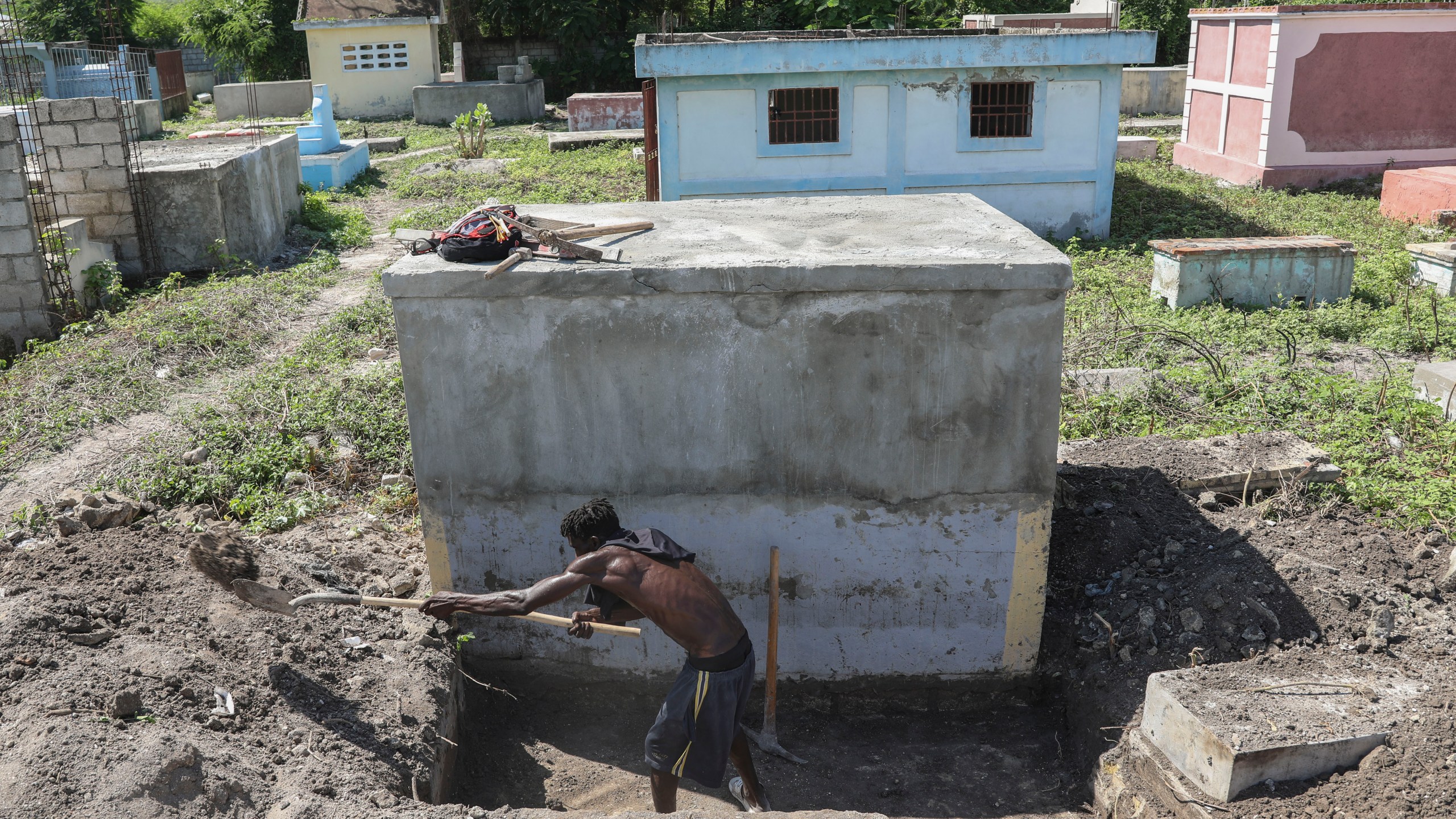 A cemetery worker prepares a grave days after a deadly gang attack on Pont-Sonde, Haiti, Tuesday, Oct. 8, 2024. (AP Photo/Odelyn Joseph)