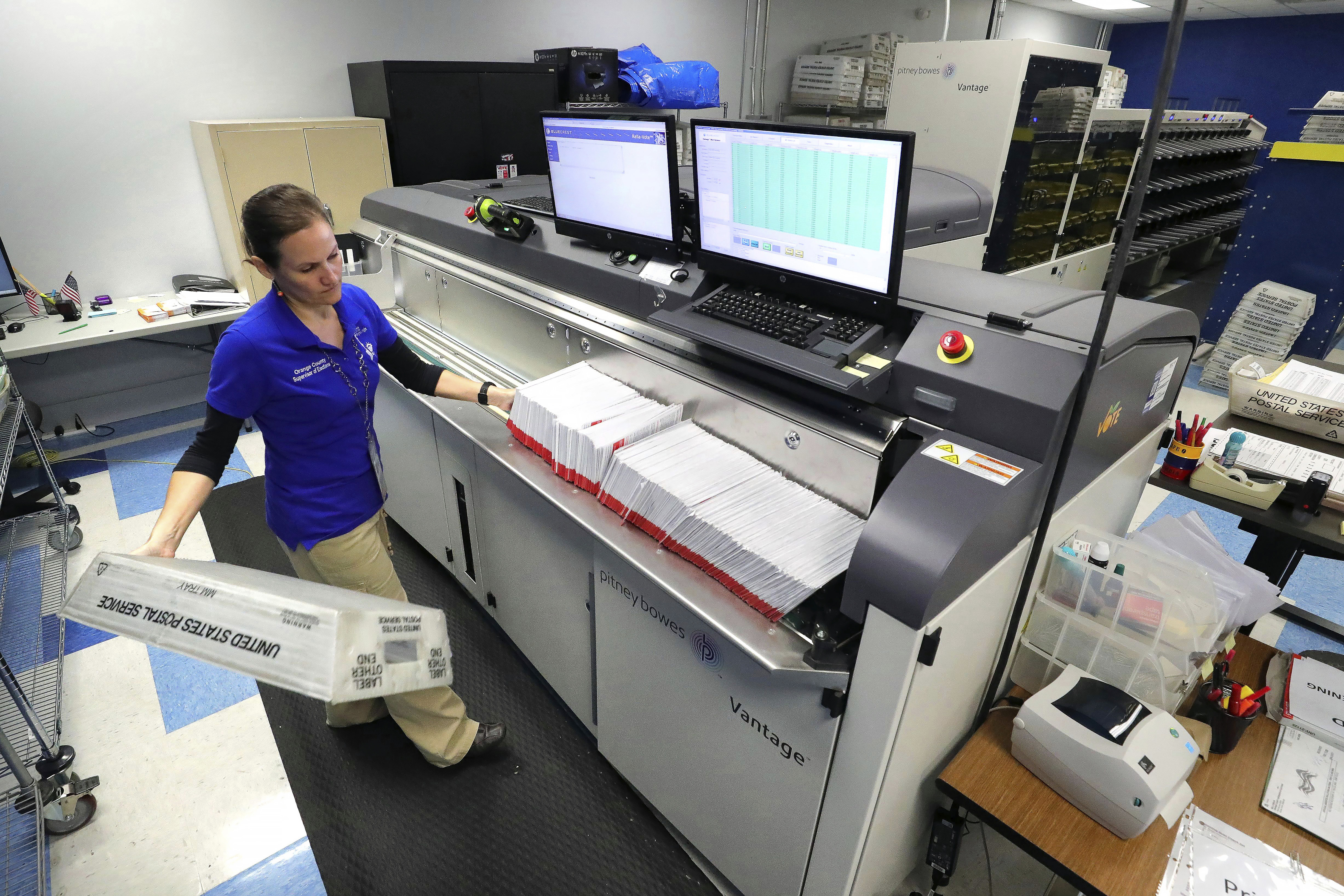 FILE - A worker processes mail-in ballots for the state's primary elections at the Orange County Supervisor of Elections office in Orlando, Fla., March 17, 2020. (Joe Burbank/Orlando Sentinel via AP, File)