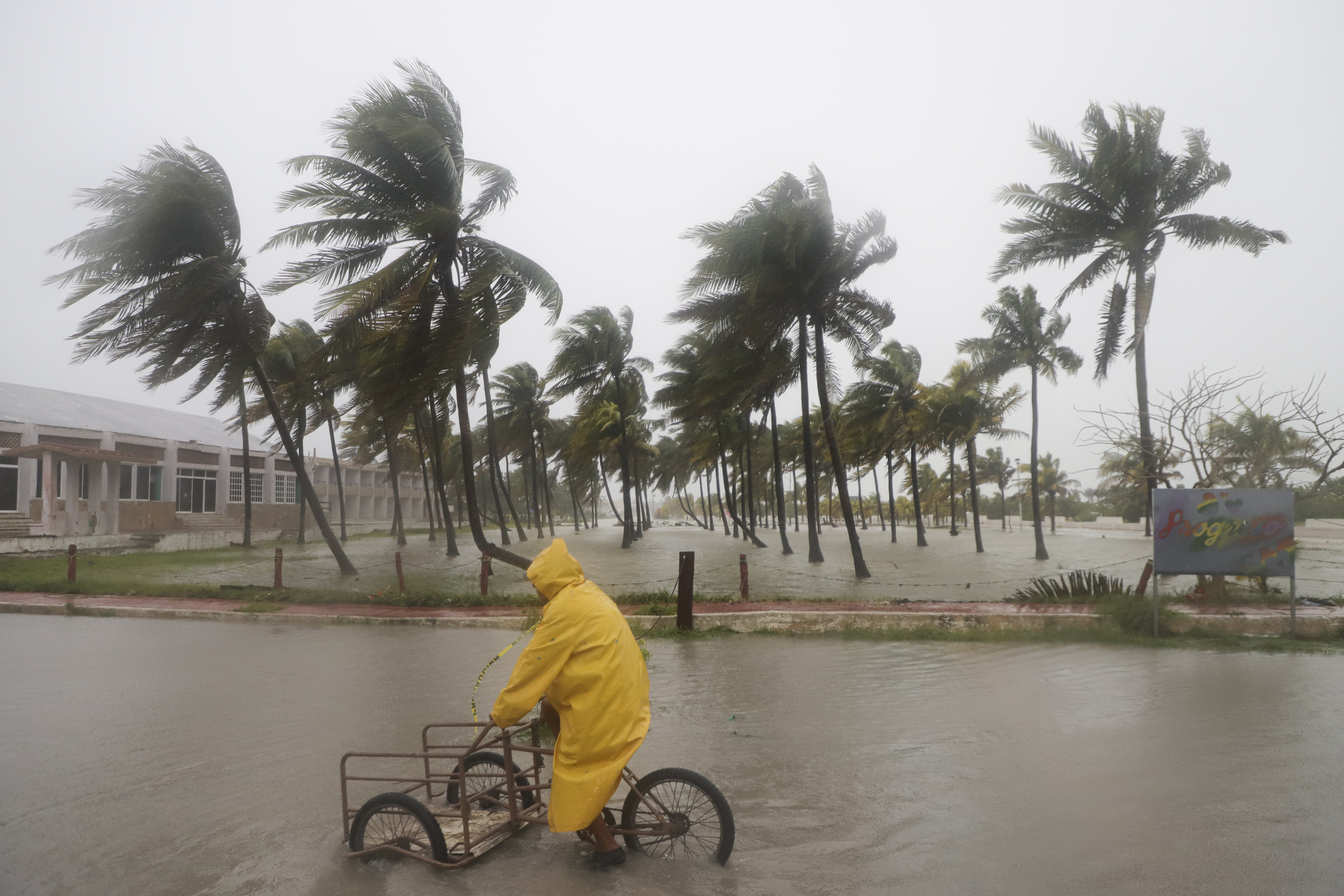 Una persona monta su bicicleta a través de una calle inundada mientras el huracán Milton pasa frente a la costa de Progreso, en el estado de Yucatán, México, el martes 8 de octubre de 2024. (AP Foto/Martin Zetina)