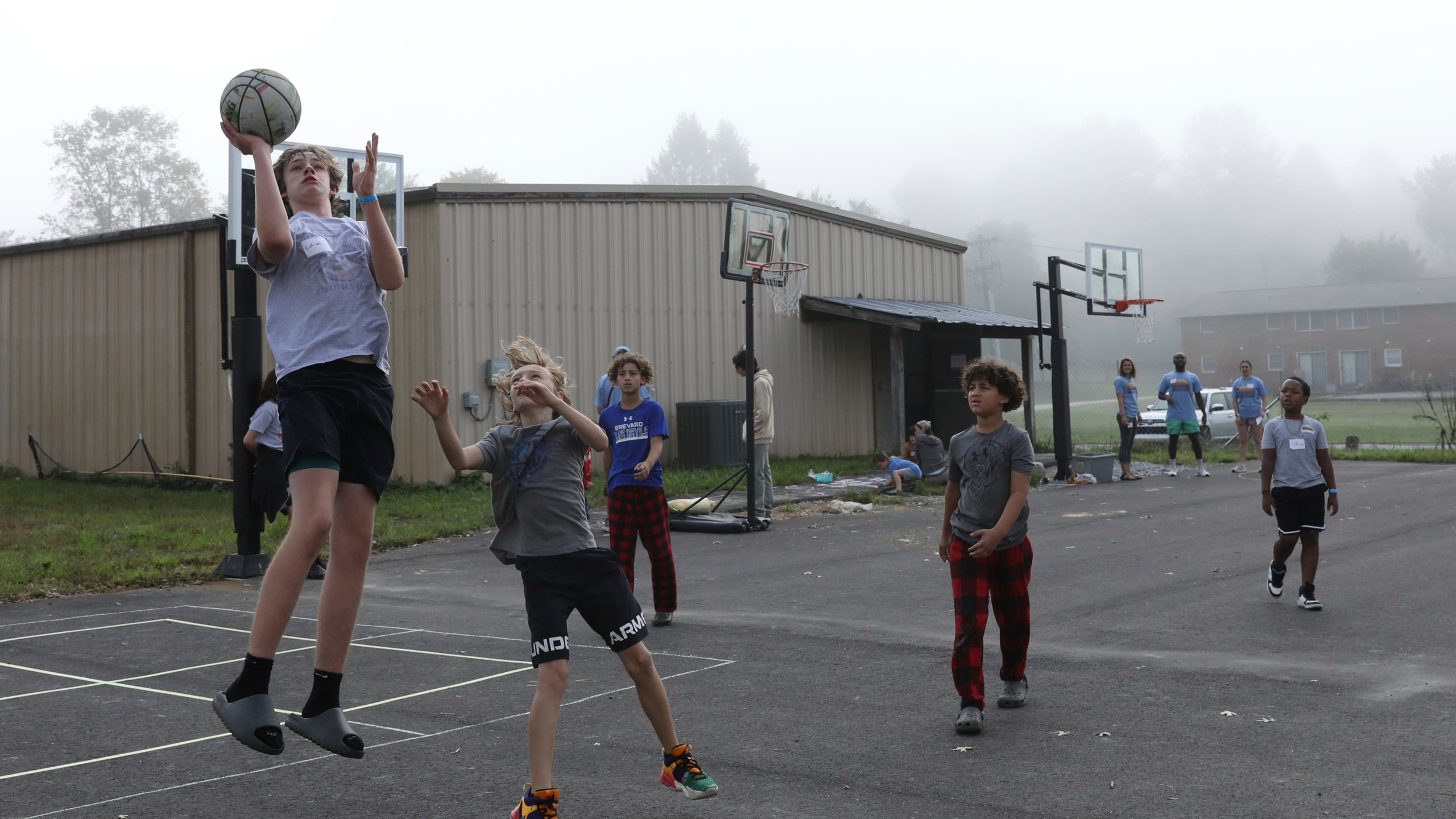 Boys play basketball at the Project:Camp pop-up daycamp for families impacted by Hurricane Helene in Brevard, N.C., Monday, Oct. 7, 2024. (AP Photo/Gabriela Aoun Angueira)