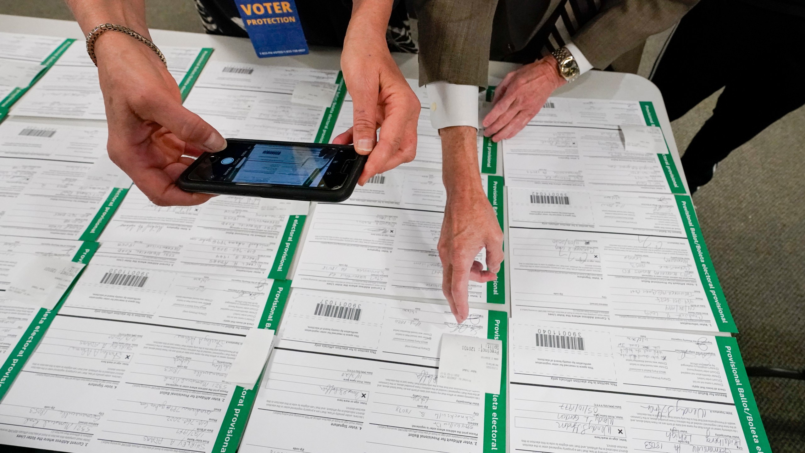 FILE - A canvas observer photographs Lehigh County provisional ballots as vote counting in the general election continues, Nov. 6, 2020, in Allentown, Pa. (AP Photo/Mary Altaffer, File)