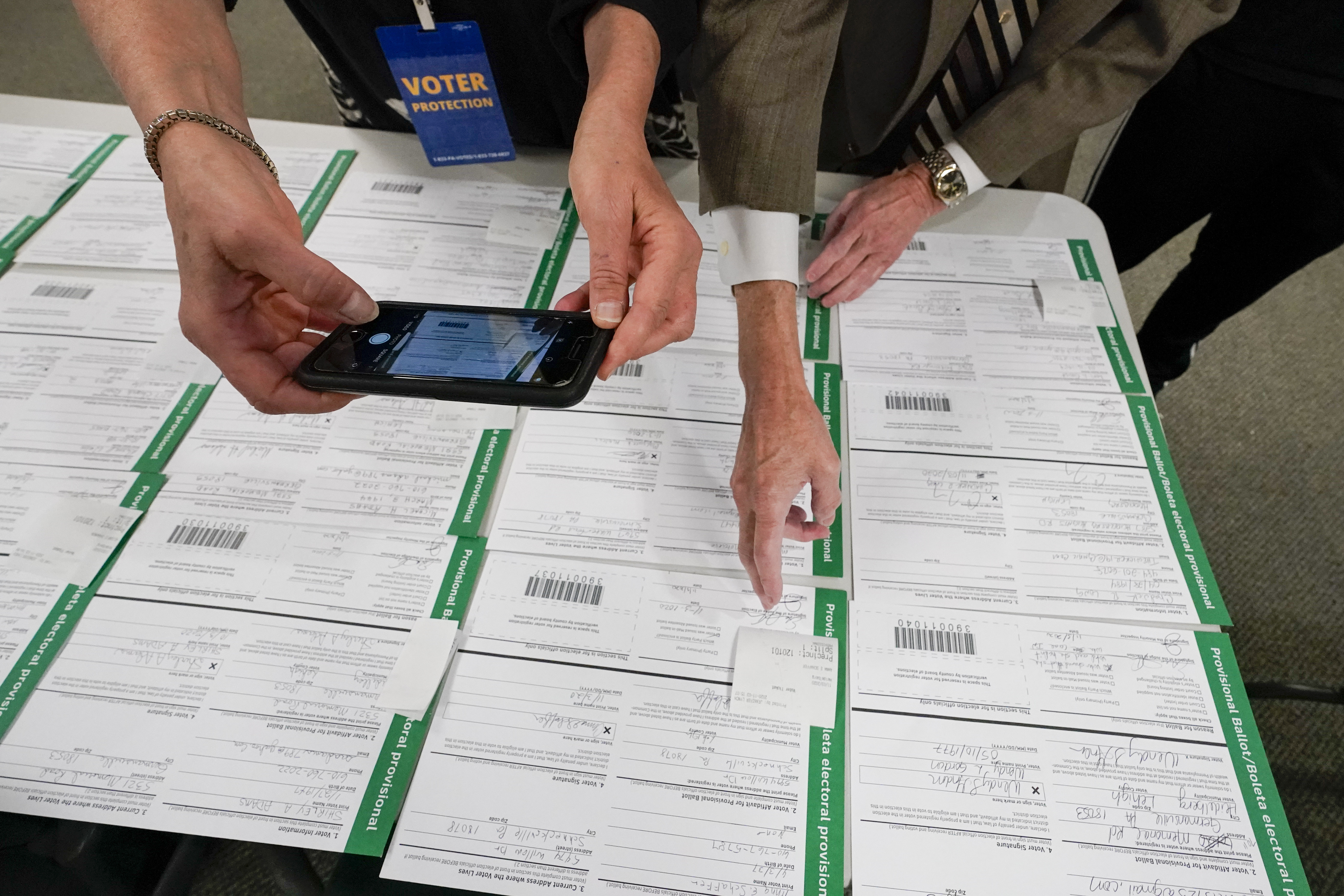 FILE - A canvas observer photographs Lehigh County provisional ballots as vote counting in the general election continues, Nov. 6, 2020, in Allentown, Pa. (AP Photo/Mary Altaffer, File)