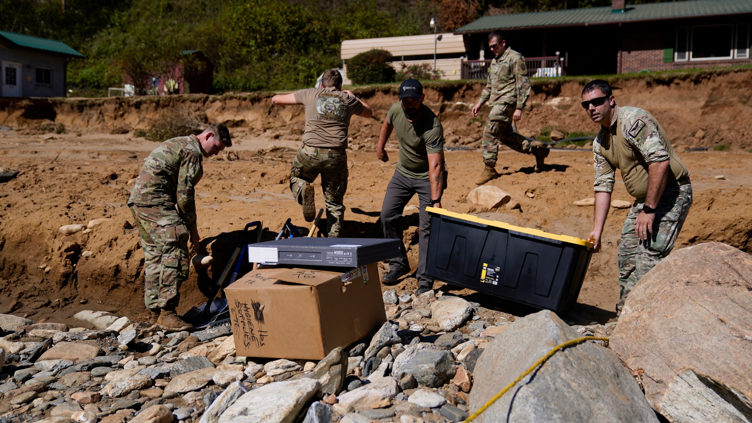 National Guard members, accompanied by a civilian volunteer, deliver supplies to residents in the aftermath of Hurricane Helene, Tuesday, Oct. 8, 2024, in Burnsville, N.C. (AP Photo/Erik Verduzco)