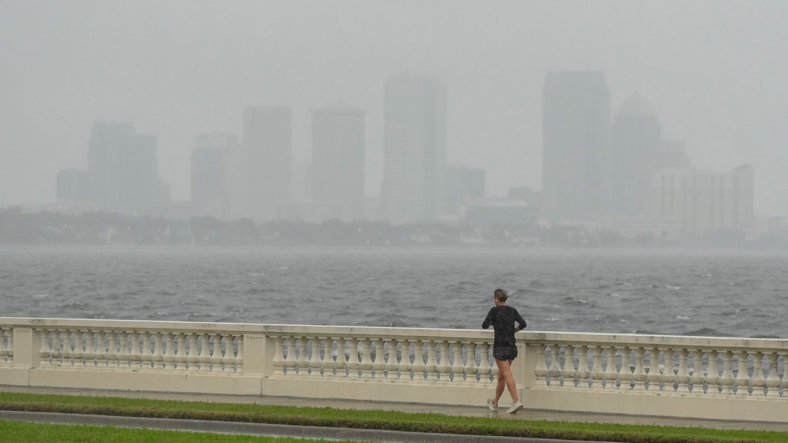 A jogger trots in light rain ahead of the arrival of Hurricane Milton, Wednesday, Oct. 9, 2024, in Tampa, Fla. (AP Photo/Julio Cortez)