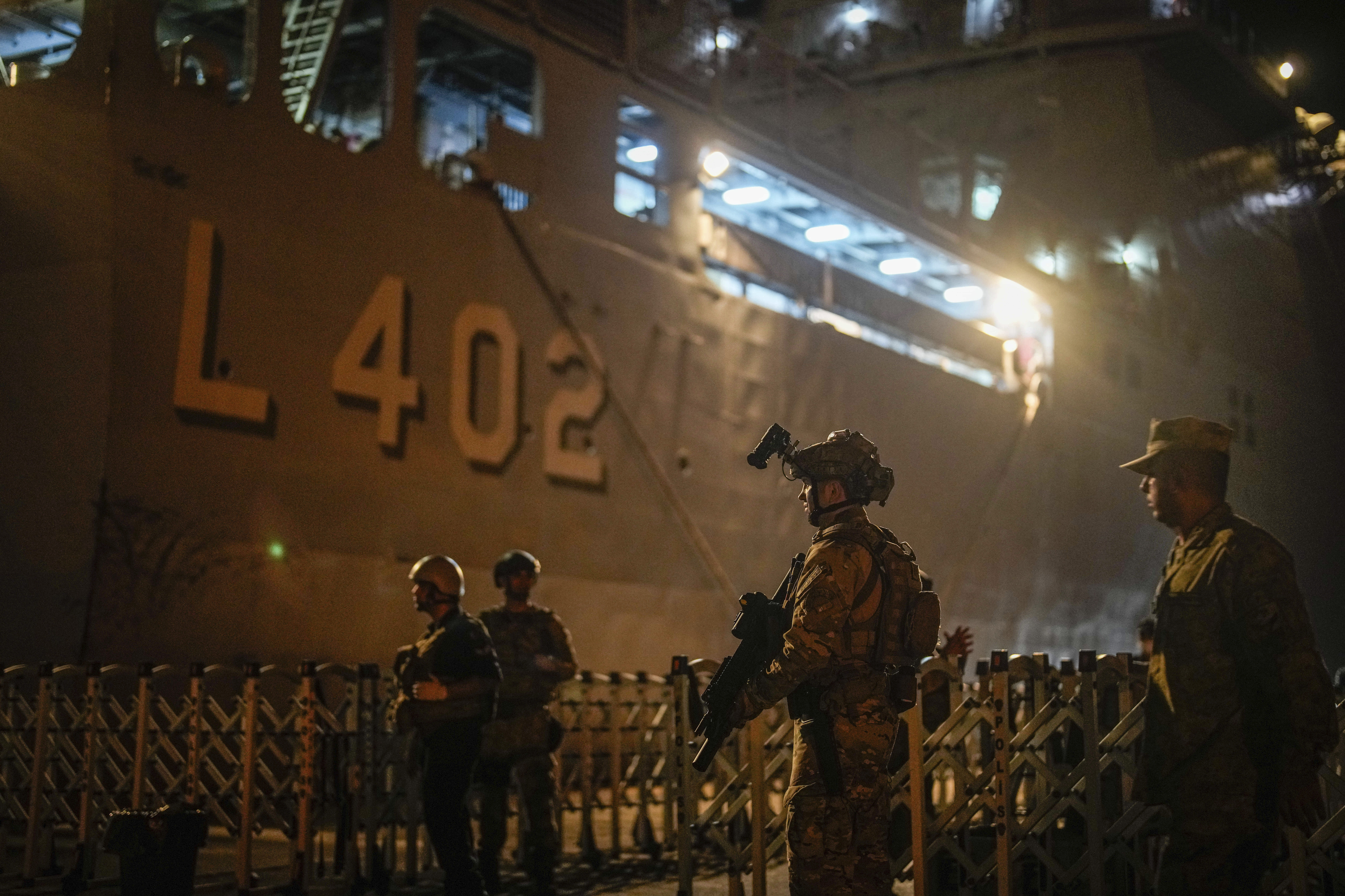 Turkish security personnel stand guard next to Turkish military ships preparing to evacuate citizens from Lebanon to Turkey in Beirut port on Wednesday, Oct. 9, 2024. (AP Photo/Emrah Gurel)