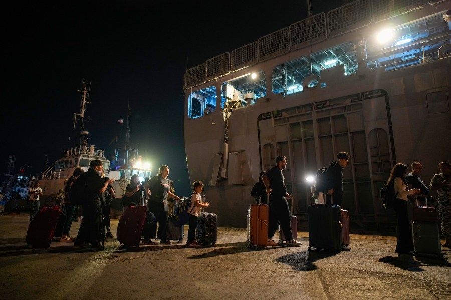 Turkish citizens walk to board Turkish military ships evacuating them from Lebanon to Turkey, in Beirut port on Wednesday, Oct. 9, 2024. (AP Photo/Emrah Gurel)