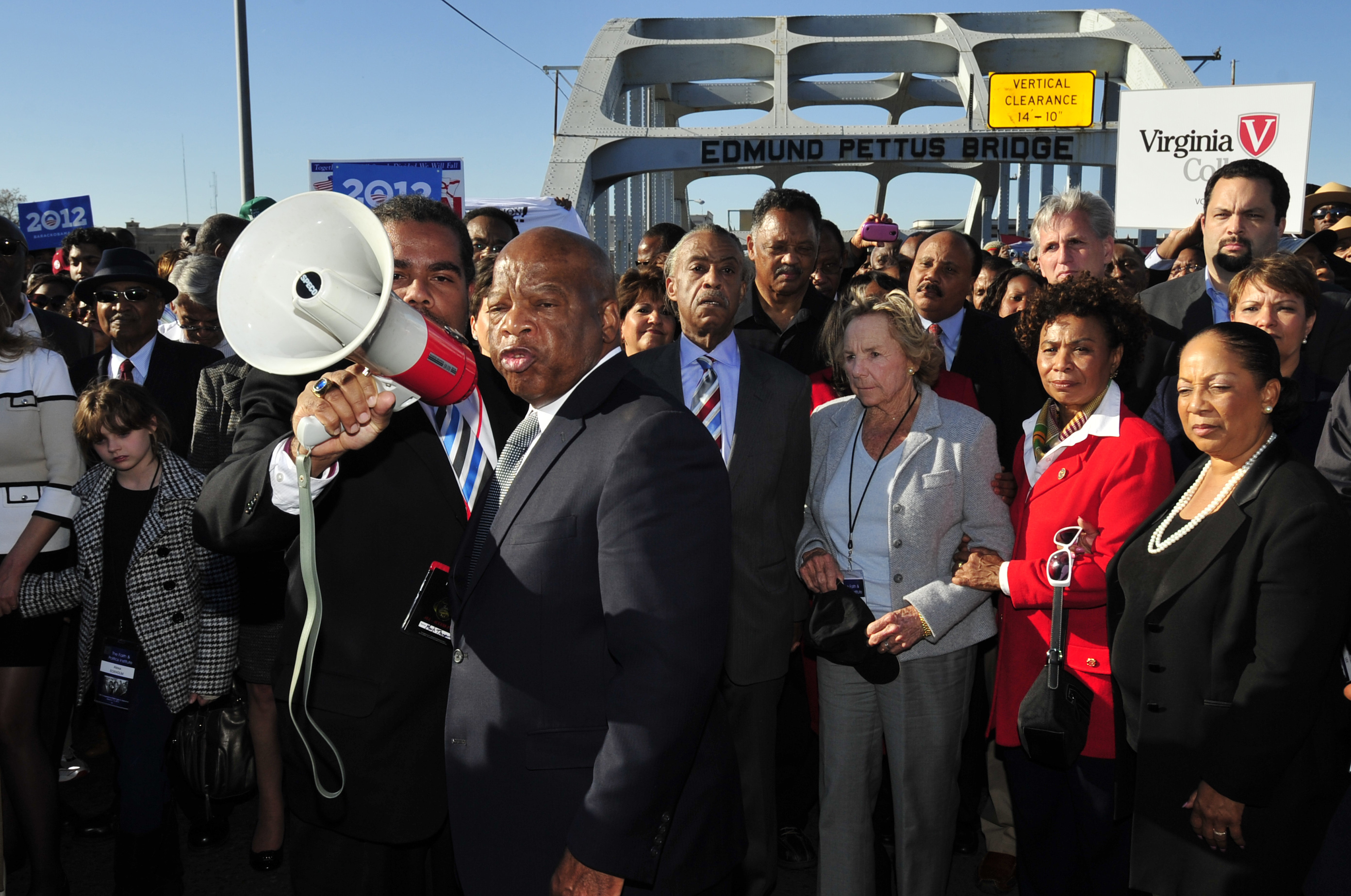 FILE - U.S. Rep. John Lewis, D-Ga., center, talks with those gathered, including Ethel Kennedy, center, and Rev. Jesse Jackson, on the historic Edmund Pettus Bridge during the 19th annual reenactment of the "Bloody Sunday" Selma to Montgomery civil rights march across the bridge in Selma, Ala., Sunday, March 4, 2012, 47 years after the historic march that led to the Voting Rights Act. (AP Photo/Kevin Glackmeyer, File)