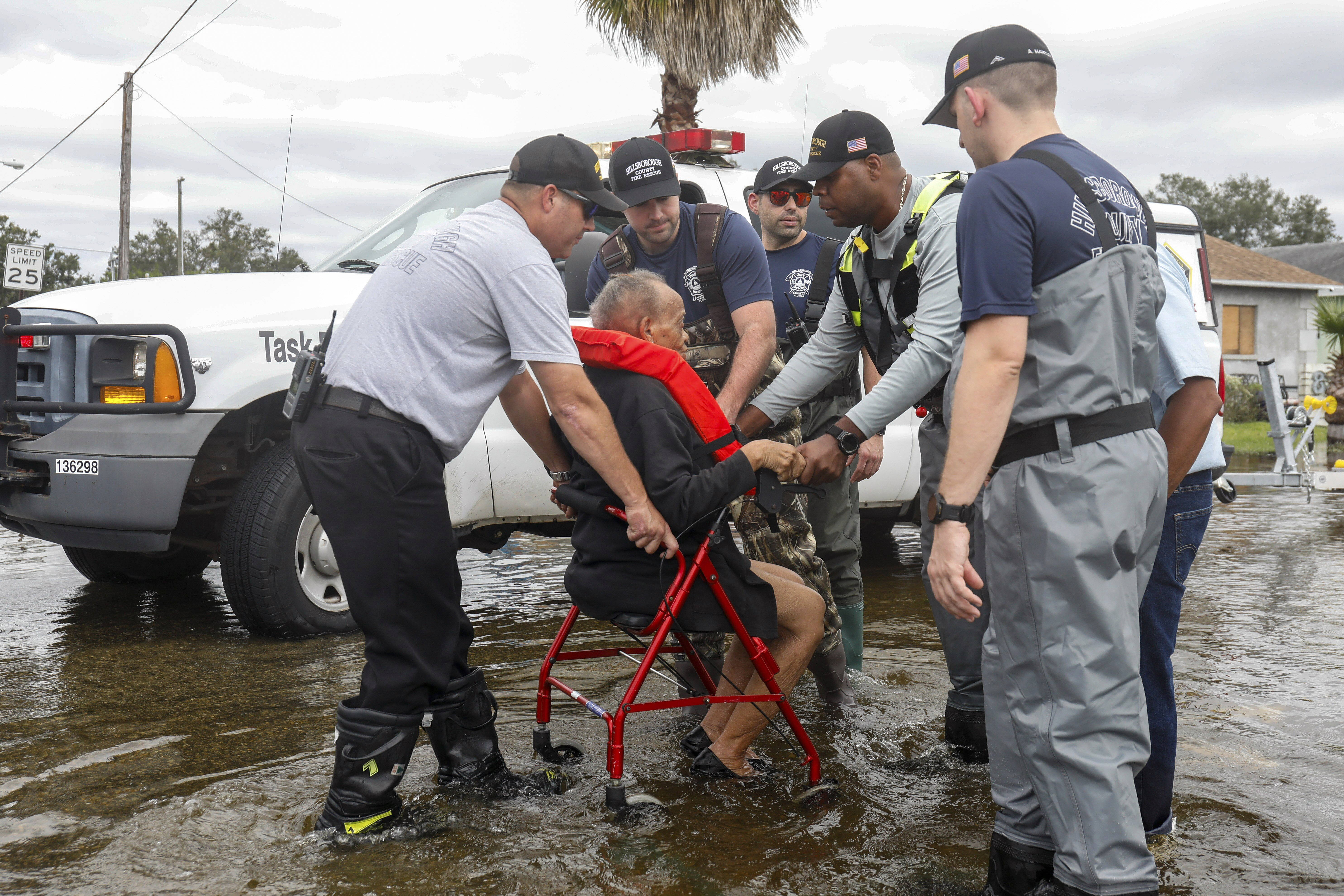 Hillsborough County fire and rescue assist local residents from their flooded homes on Thursday, Oct. 10, 2024, in Progress Village Community, Fla. (Jefferee Woo/Tampa Bay Times via AP)