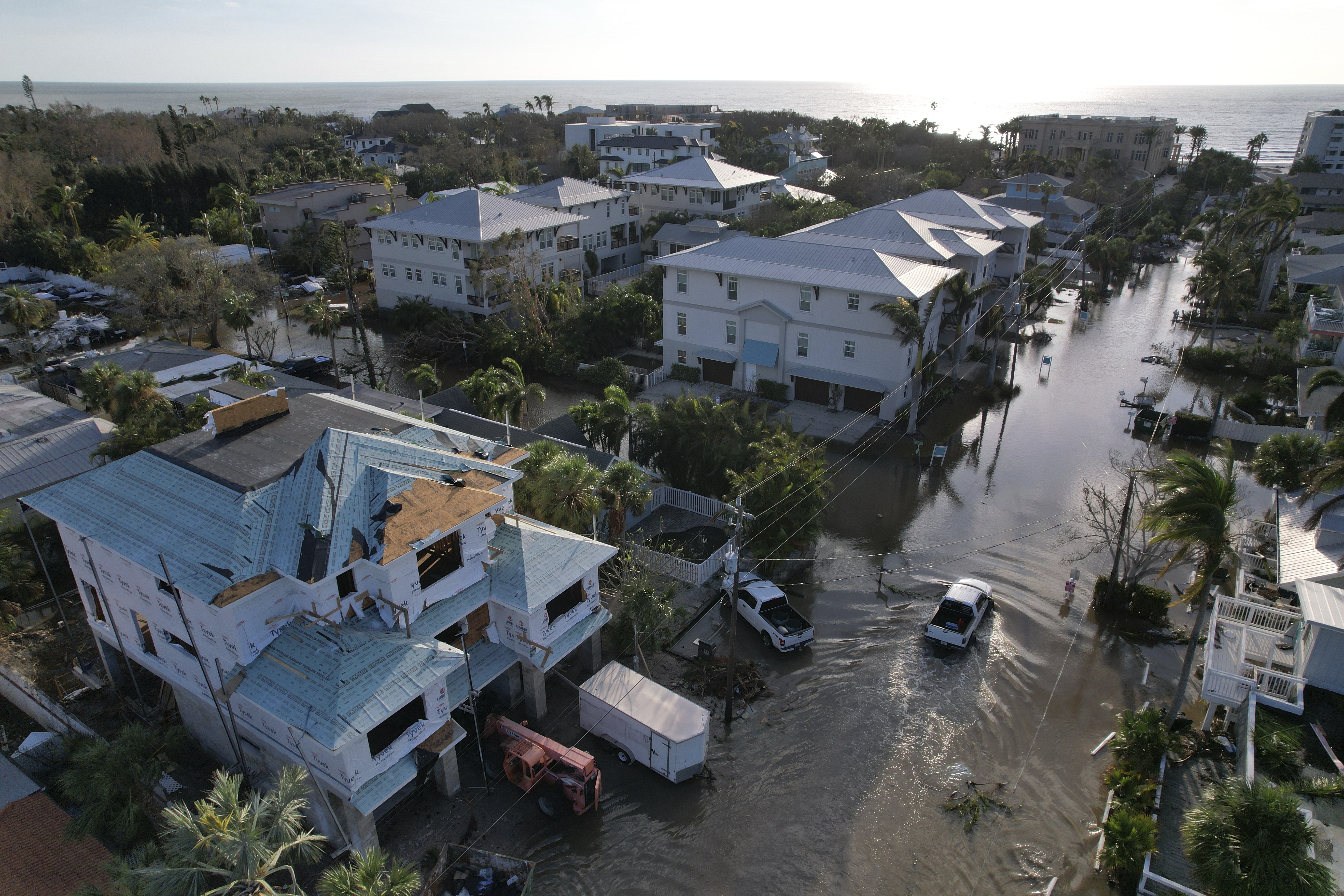 A truck drives down a flooded street in Siesta Key, Fla., following the passage of Hurricane Milton, Thursday, Oct. 10, 2024. (AP Photo/Rebecca Blackwell)