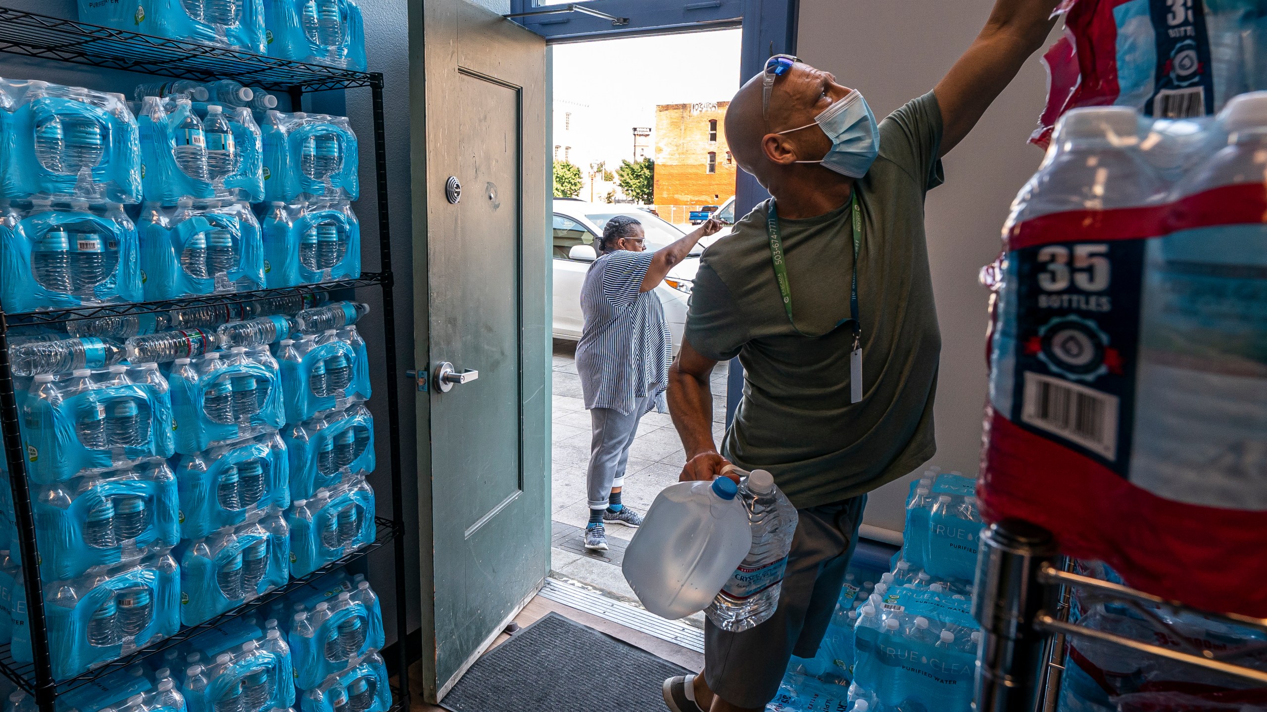 FILE - Chris Cowan with Cascadia Behavioral Healthcare's street outreach team loads water and other cooling supplies before visiting homeless camps, Aug. 12, 2021, in Portland, Ore. (AP Photo/Nathan Howard, File)