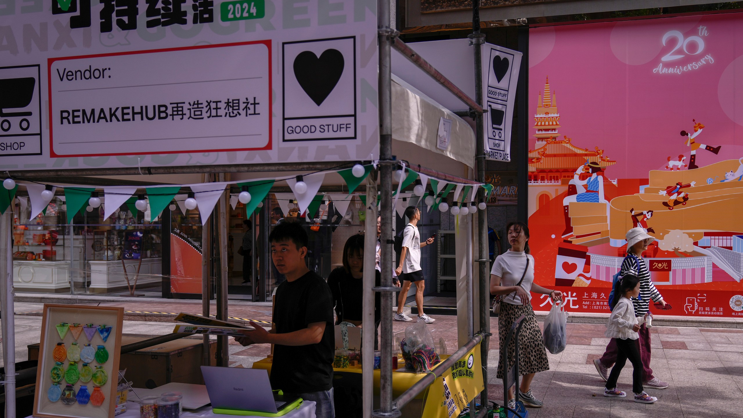 People walk by vendors set up their stores at a popular shopping district in Shanghai, China, Saturday, Oct. 12, 2024. (AP Photo/Andy Wong)