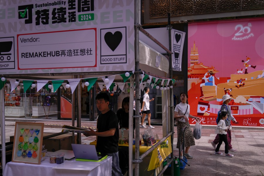 People walk by vendors set up their stores at a popular shopping district in Shanghai, China, Saturday, Oct. 12, 2024. (AP Photo/Andy Wong)