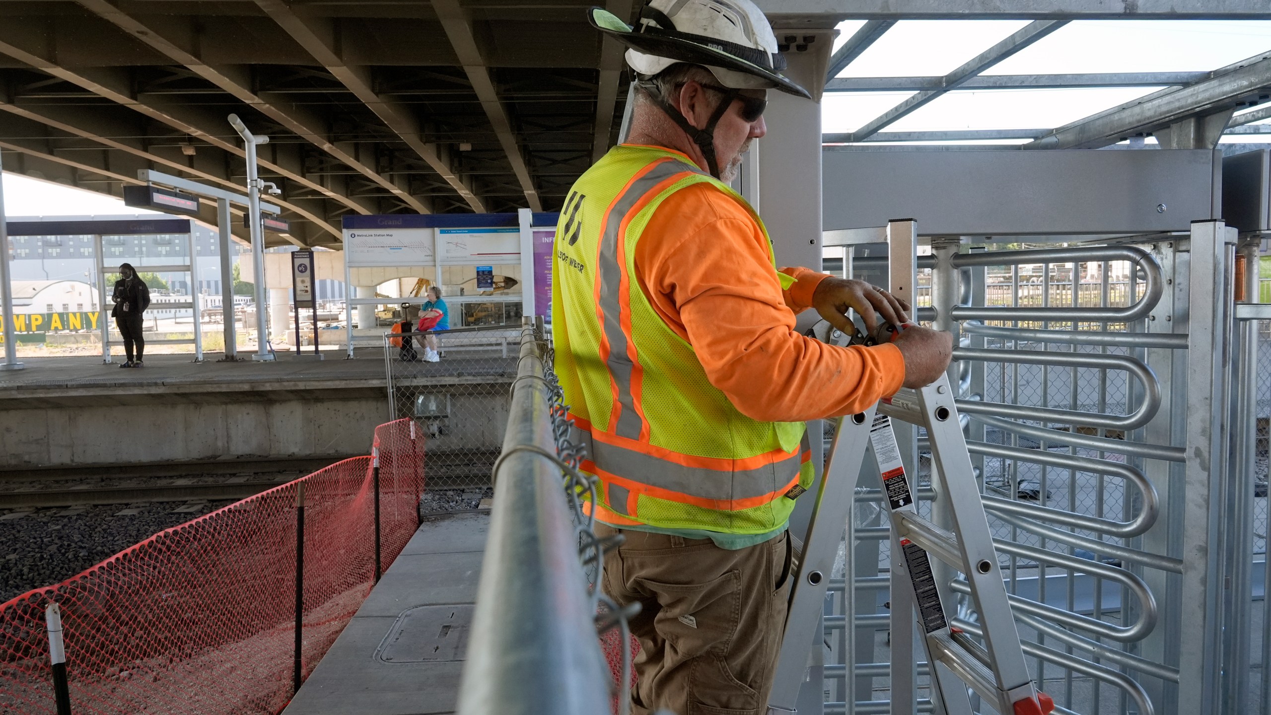 Gary Baalman with Millstone Weber construction works to install metal a gate that will prevent customers from entering a MetroLink platform without a valid fare card Wednesday, Oct. 9, 2024, in St. Louis. (AP Photo/Jeff Roberson)