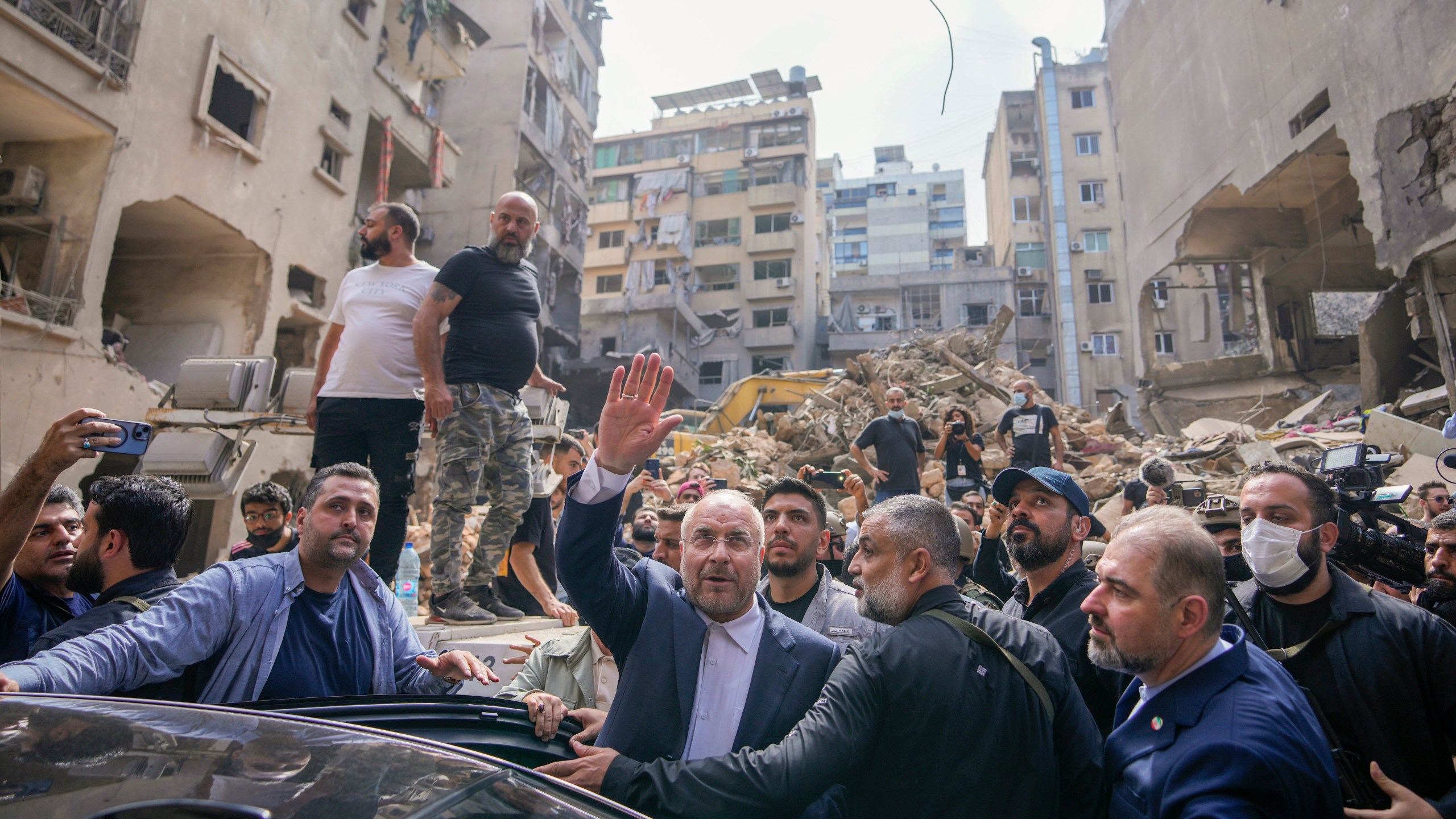 Iran's parliament speaker Mohammad Bagher Qalibaf waves to residents as visit the site of Thursday's Israeli airstrike, in Beirut, Lebanon, Saturday, Oct. 12, 2024. (AP Photo/Hassan Ammar)