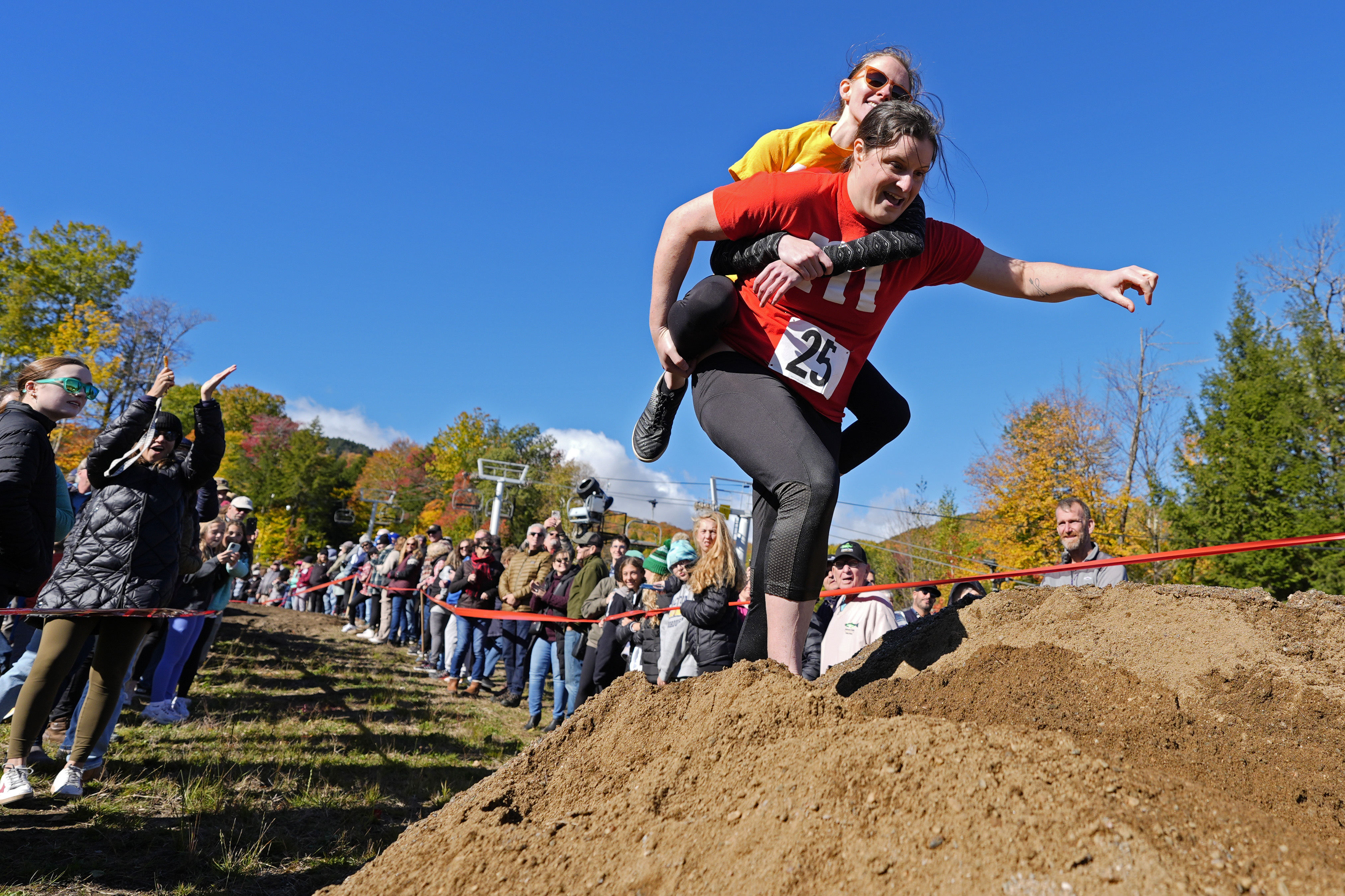 Molly Sunburn carries Megan Crowley over a sand pile during the North American Wife Carrying Championship, Saturday, Oct. 12, 2024, at Sunday River ski resort in Newry, Maine. (AP Photo/Robert F. Bukaty)