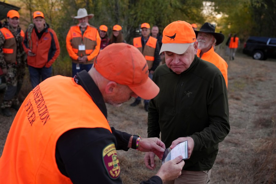 Tim Walz, Minnesota governor and Democratic vice presidential candidate, gets his hunting license ceremoniously inspected before heading out for the annual Minnesota Governor's Pheasant Hunting Opener near Sleepy Eye, Minn., Saturday, Oct. 12, 2024. (Anthony Souffle/Star Tribune via AP)