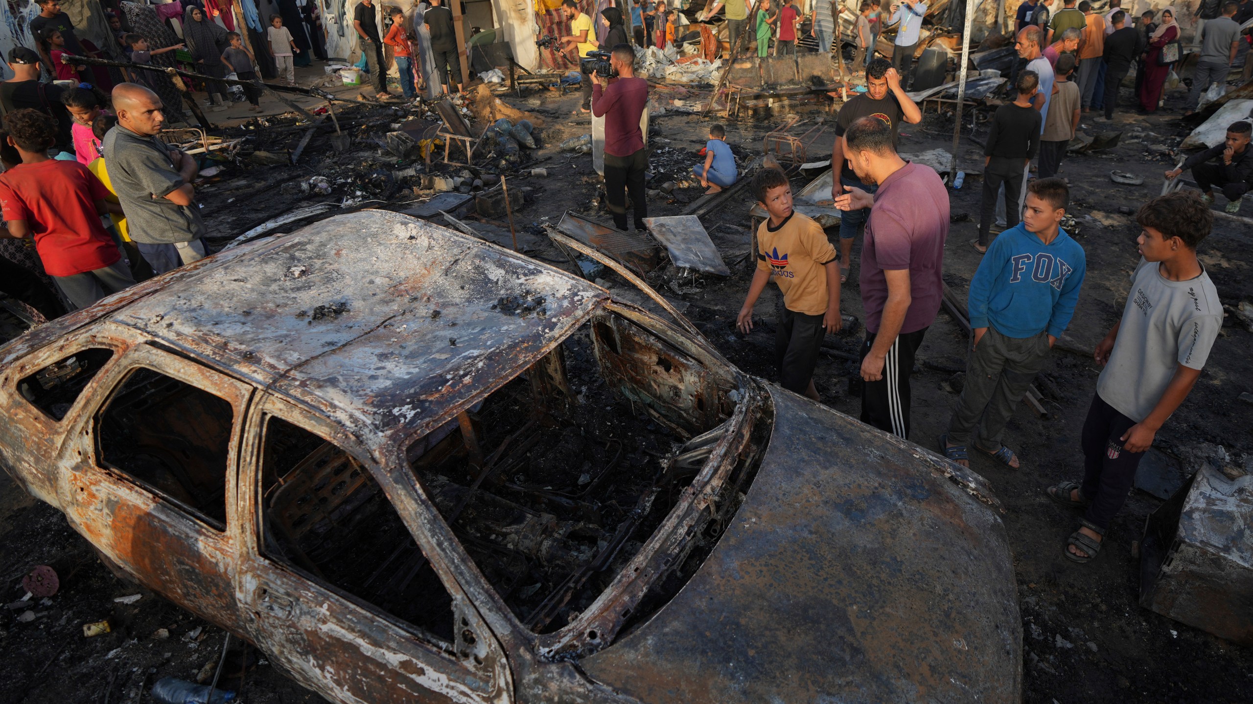 Palestinians look at the damage after an Israeli strike hit a tent area in the courtyard of Al Aqsa Martyrs hospital in Deir al Balah, Gaza Strip, Monday, Oct. 14, 2024. (AP Photo/Abdel Kareem Hana)